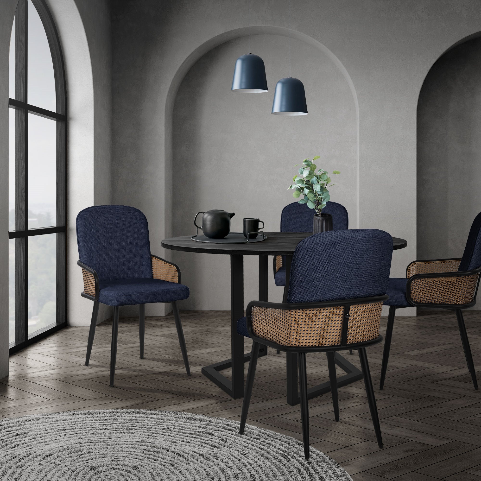 A modern dining area with a round table, four chairs, and large windows.