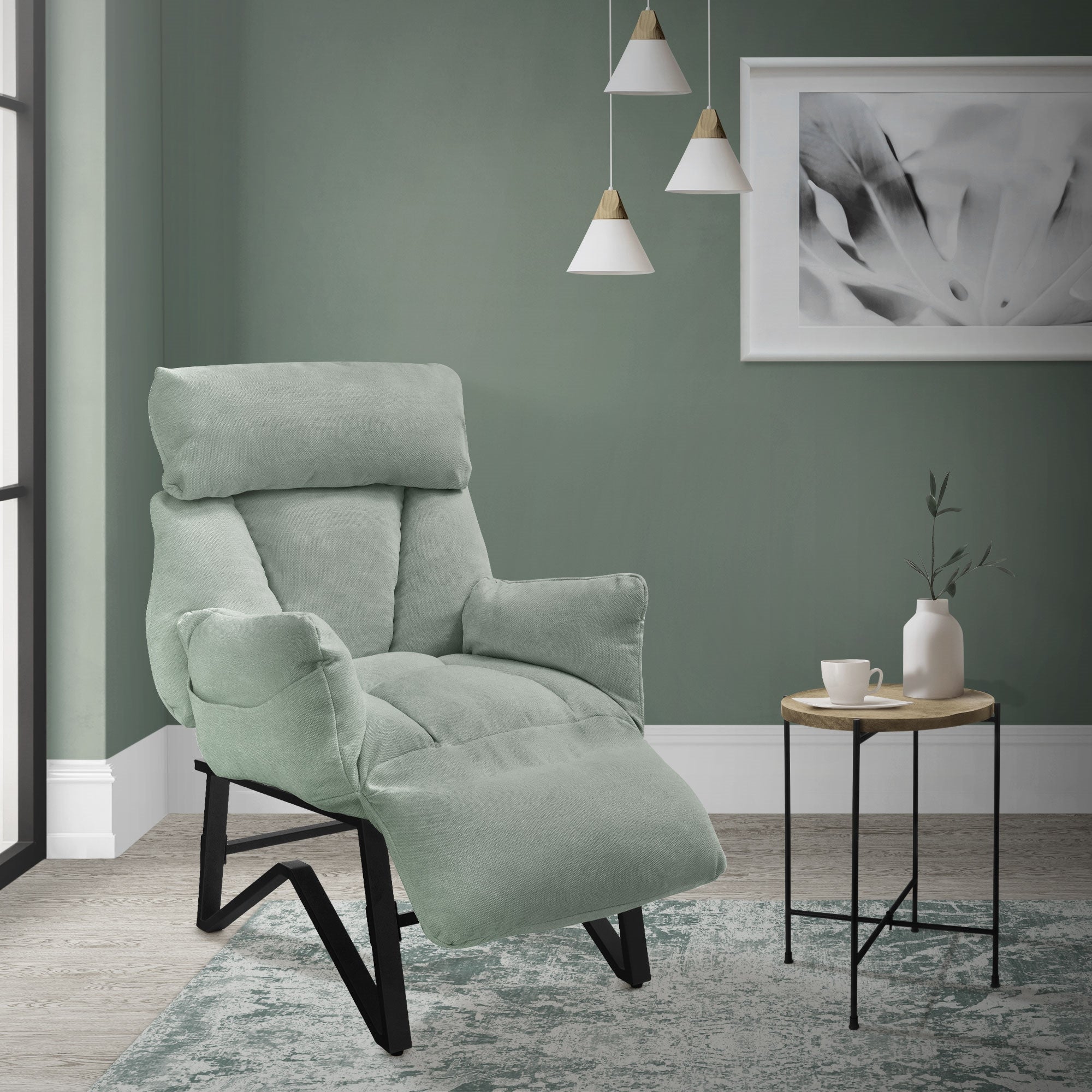 Sillón en una habitación con pared verde, mesa y decoración.