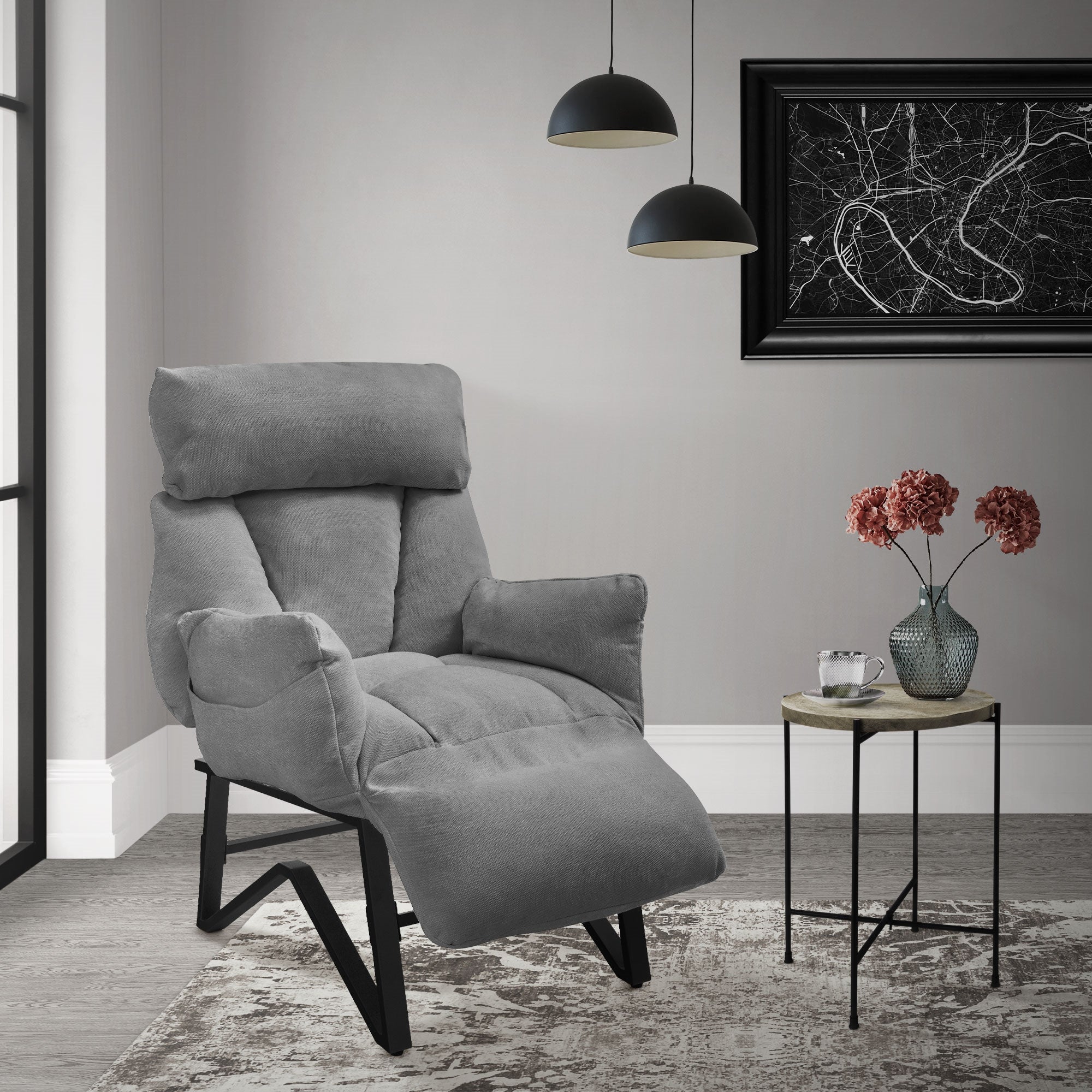 Sillón gris en una habitación moderna con mesa y flores.