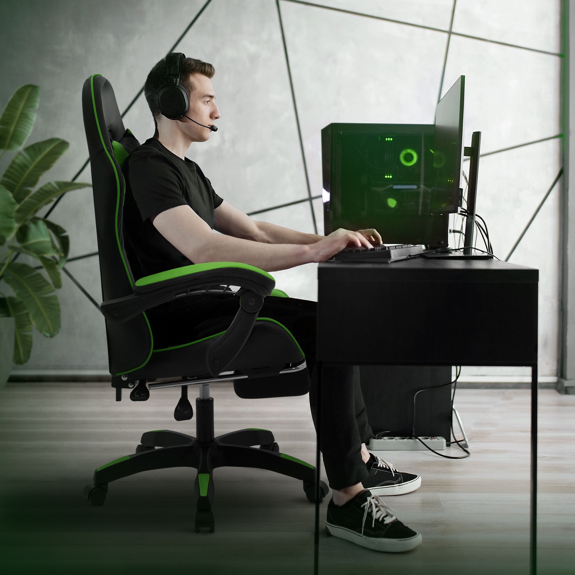 Ung mand med headset sidder ved skrivebord og bruger gaming-PC.