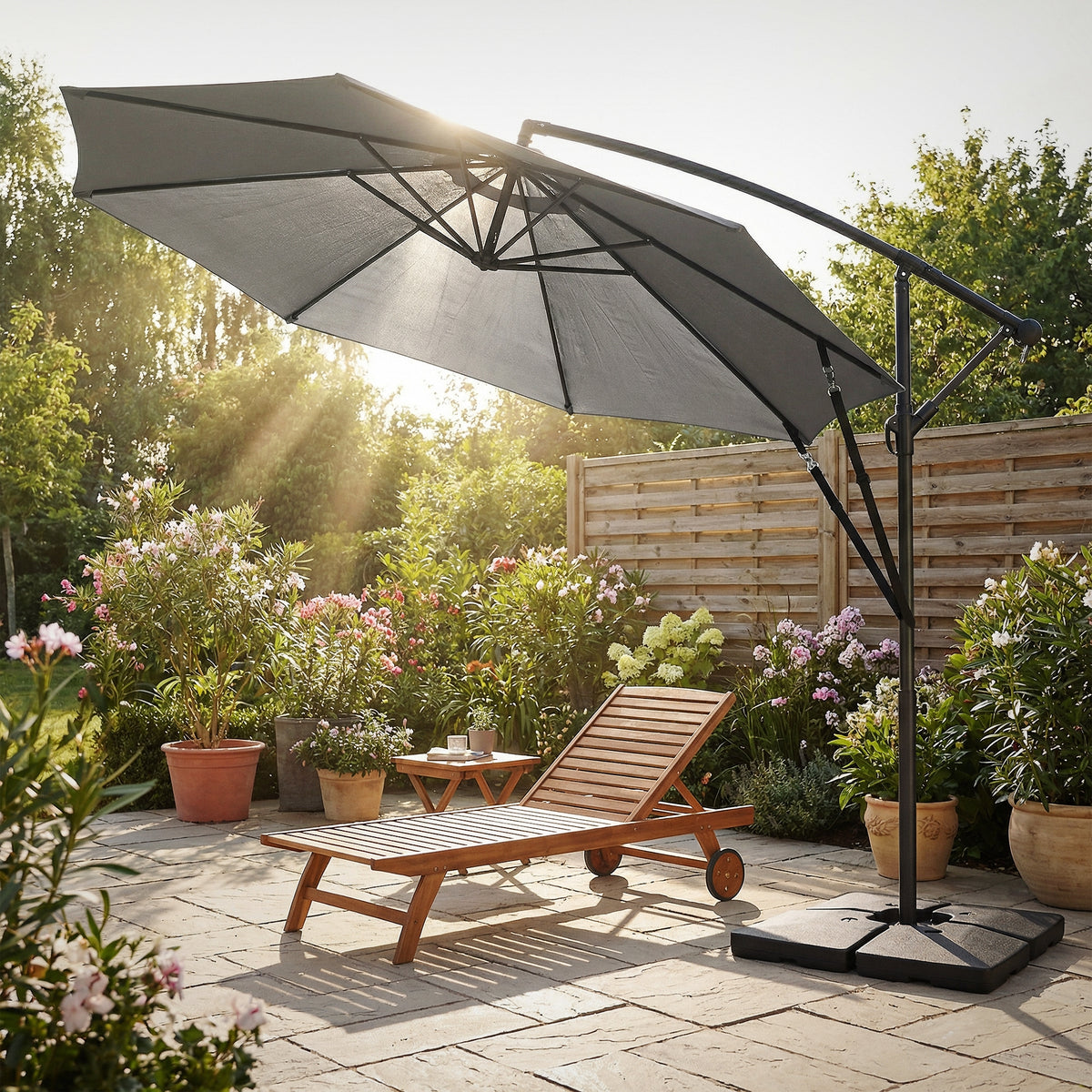 Sonnenliege mit Sonnenschirm in einem Garten mit Blumen und Pflanzen.