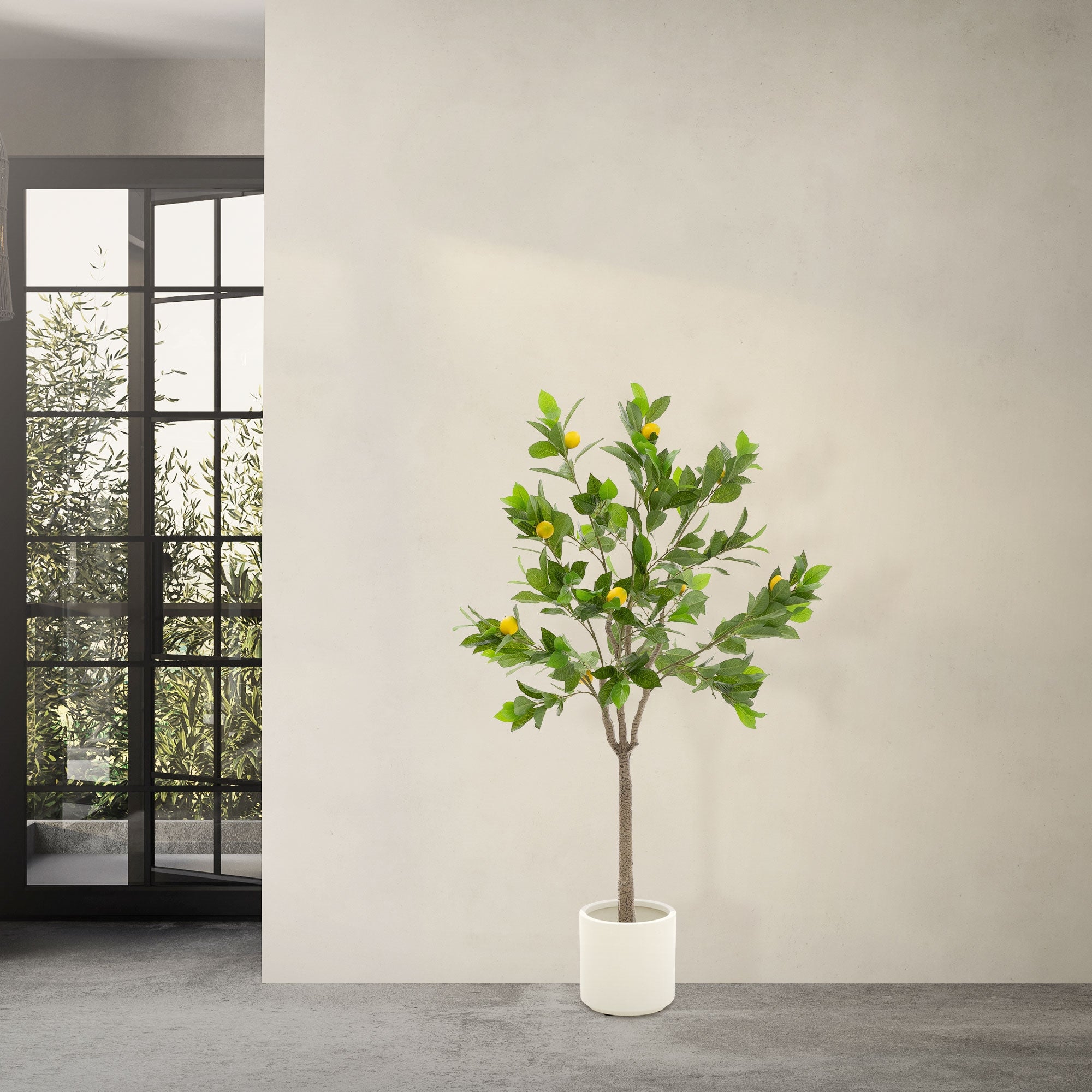 Ein künstlicher Baum mit grünen Blättern und gelben Früchten in einem weißen Topf.