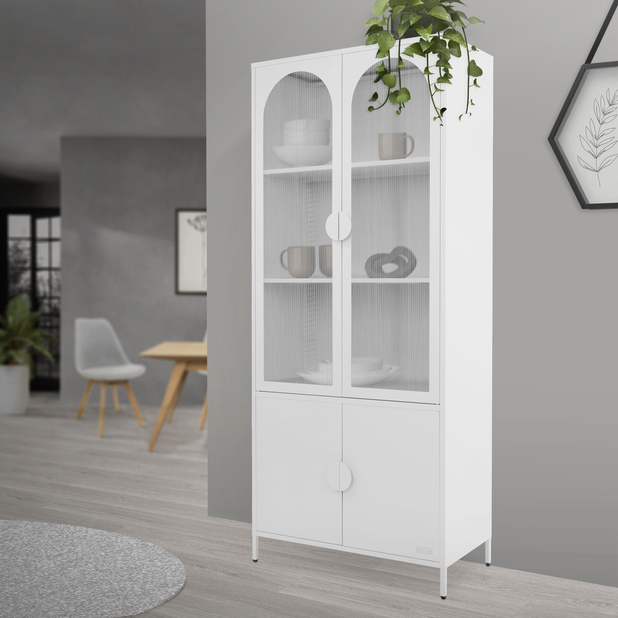 Armoire blanche avec des portes en verre et des plantes en arrière-plan.