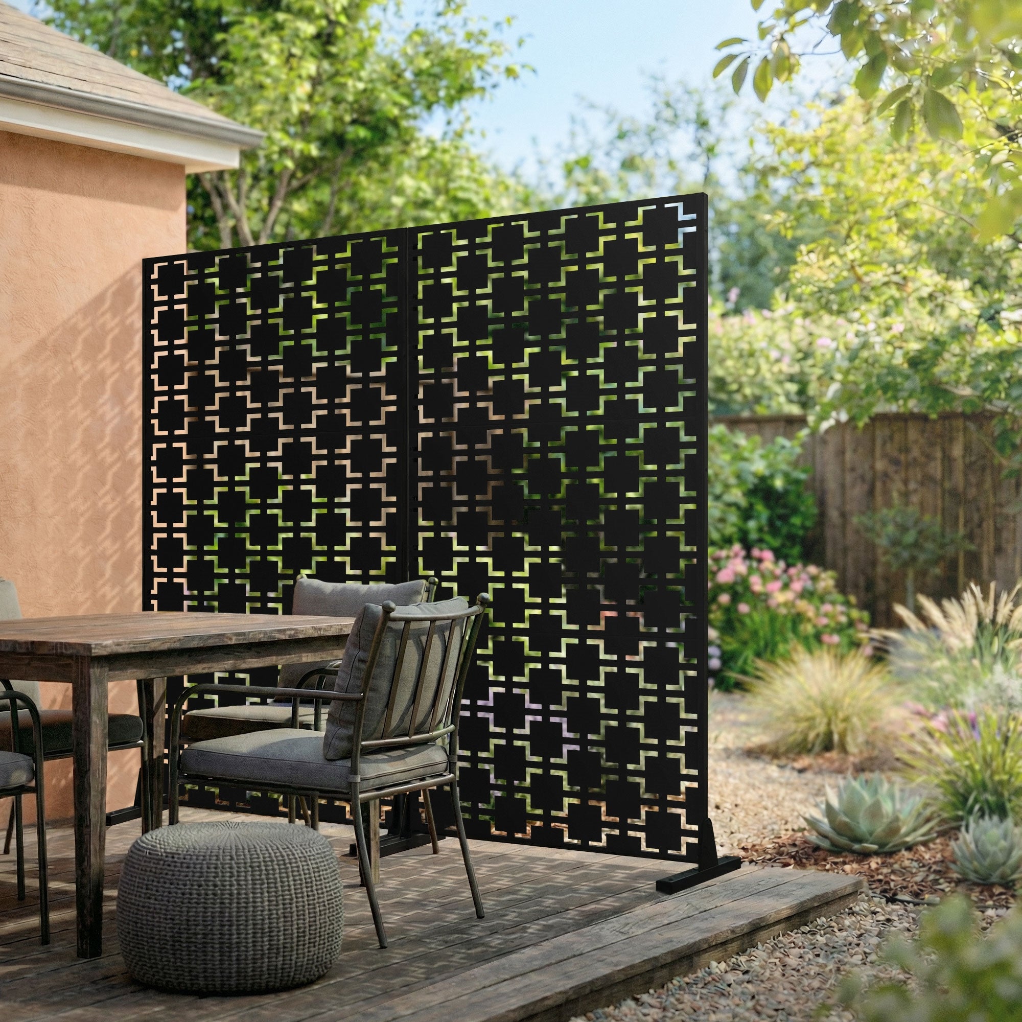 Black privacy screen made of metal with geometric pattern, set up in the garden.