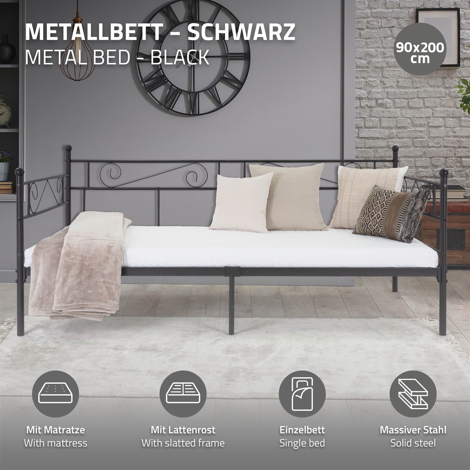 Zwart metalen bed met matras, lattenbodem en kussen.