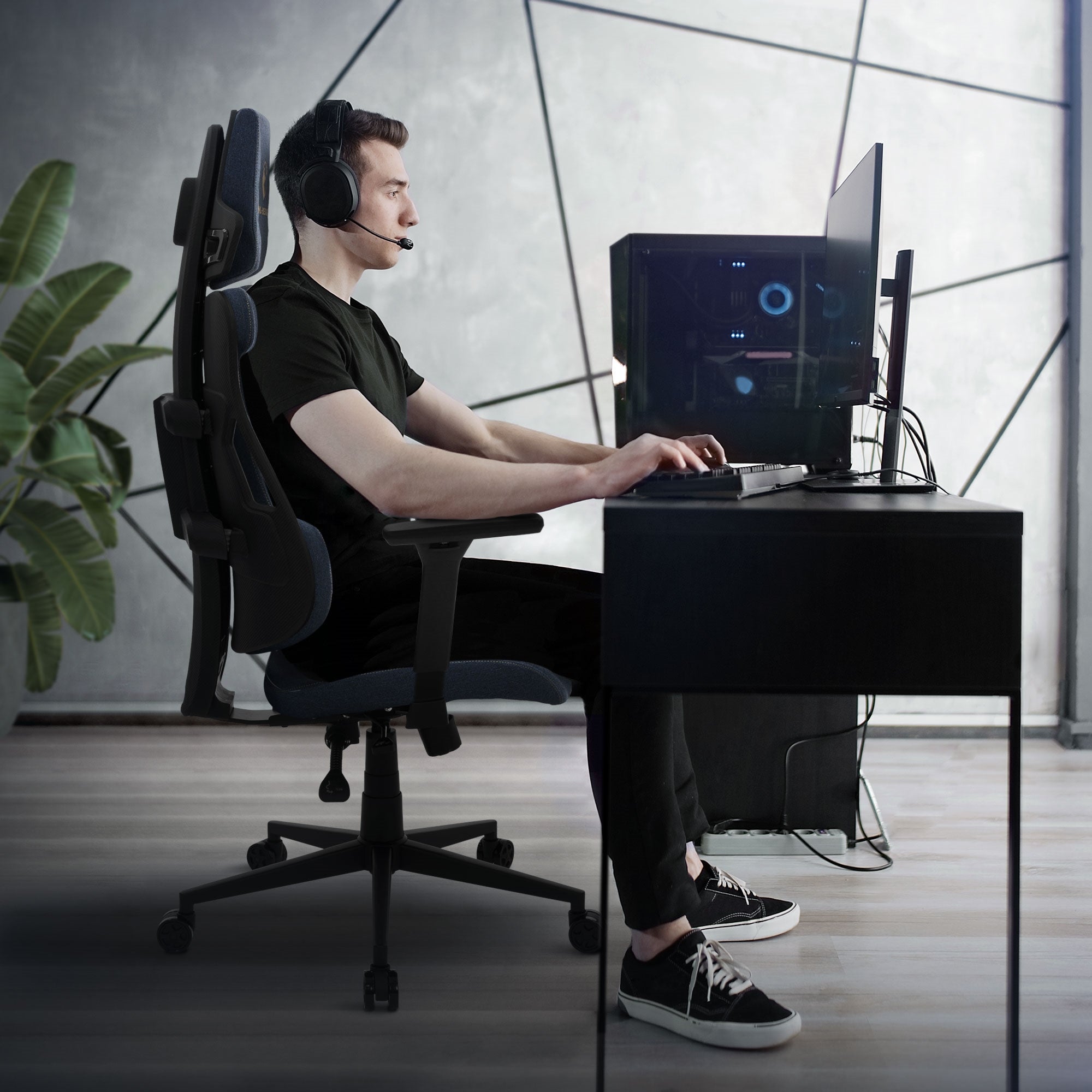 Giovane uomo seduto a una scrivania su una sedia da gaming.