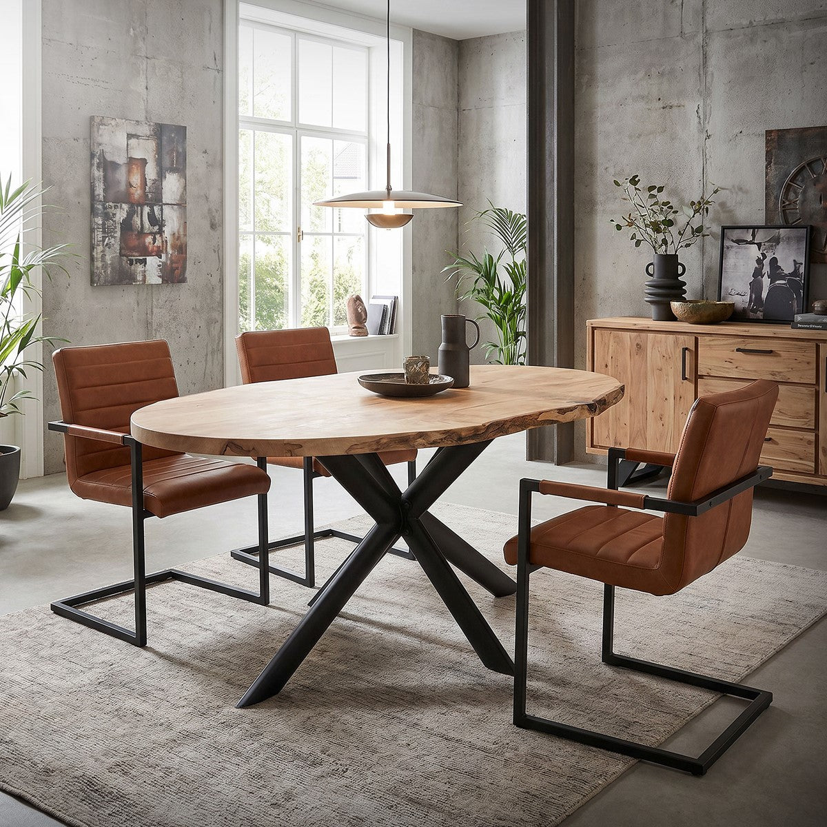 Modern matgrupp med rund bordsskiva i trä och fyra bruna stolar.