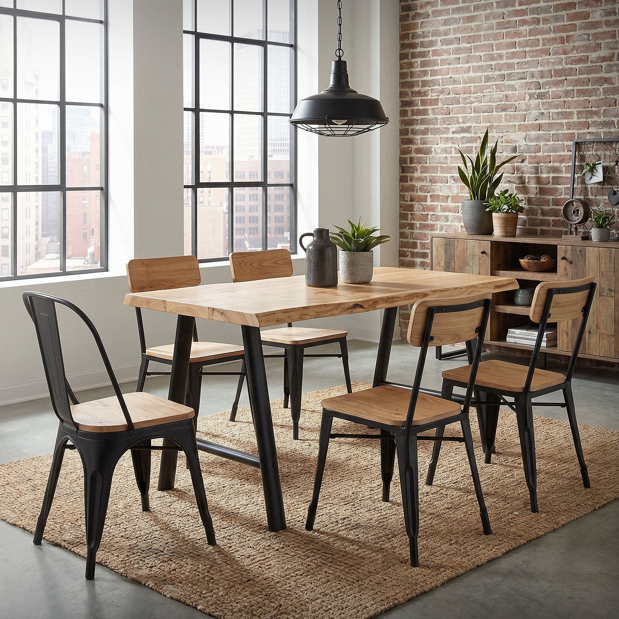 Una sala da pranzo con un tavolo in legno e cinque sedie davanti a grandi finestre.