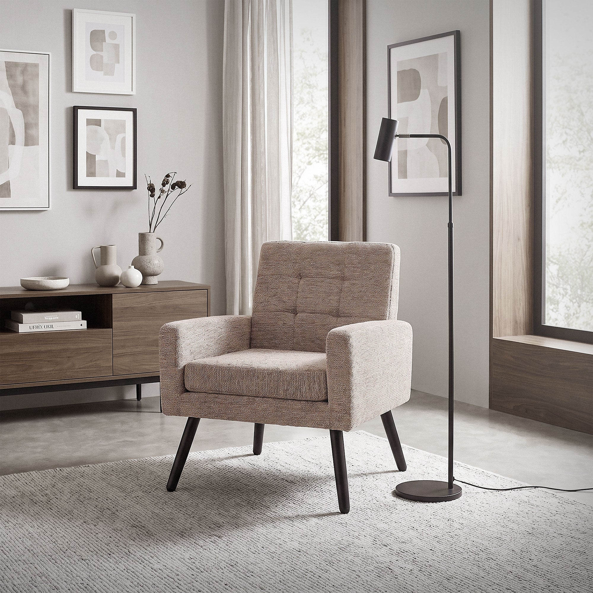 A gray armchair in a modern room with pictures on the wall.