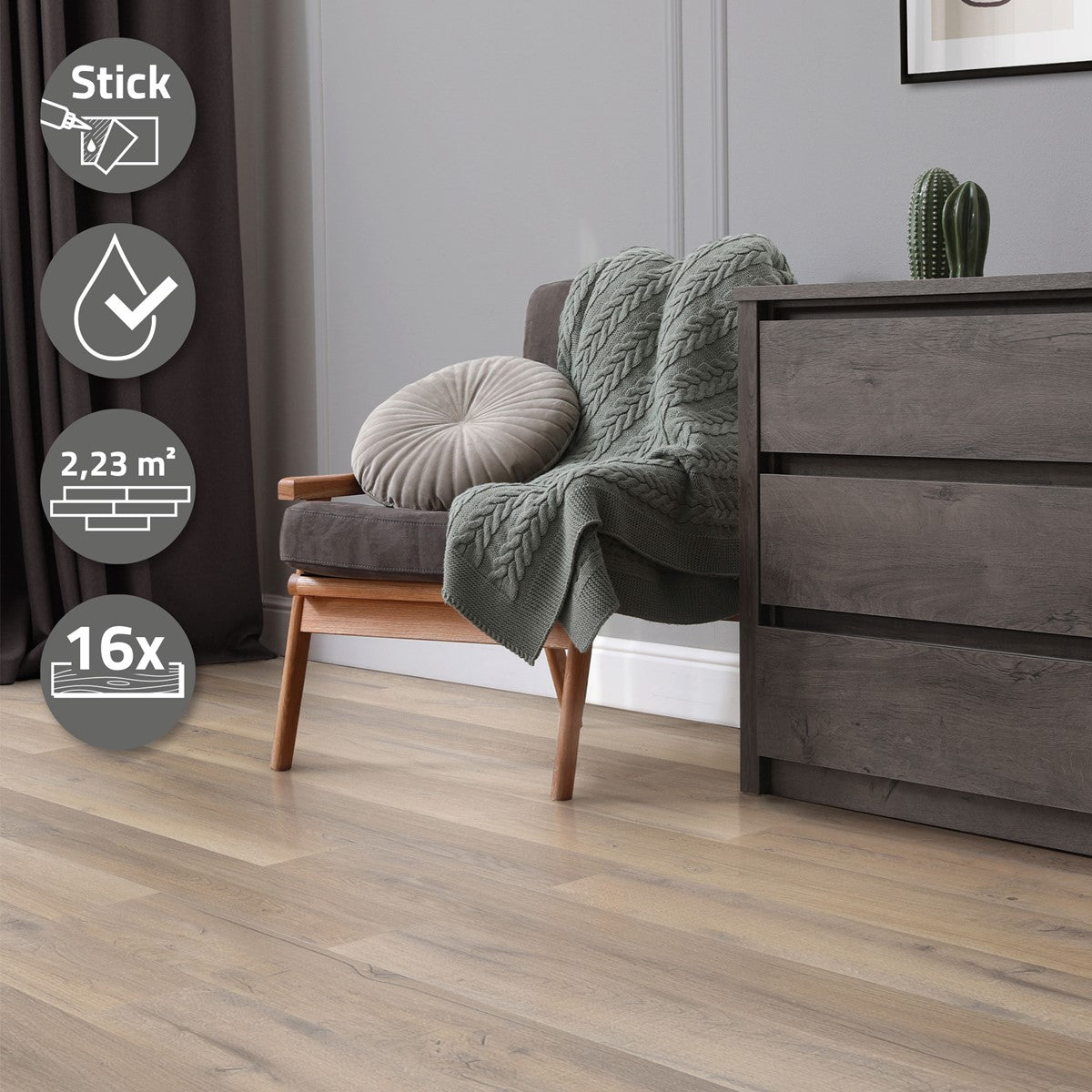 Ein graues Sofa mit einer Decke und einem Kissen, daneben ein Holzschrank.