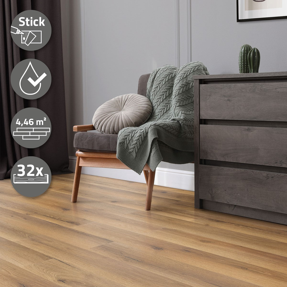Ein graues Sofa mit einer Decke und einem Kissen, daneben ein Holzschrank.