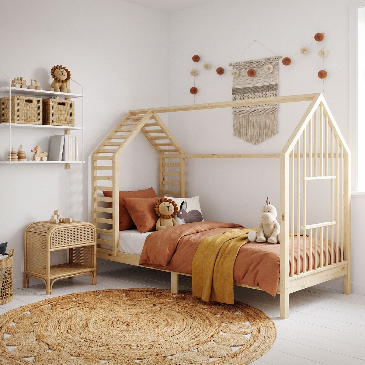 Ein Kinderzimmer mit einem Bett in Hausform, Teppich und Wanddekoration.