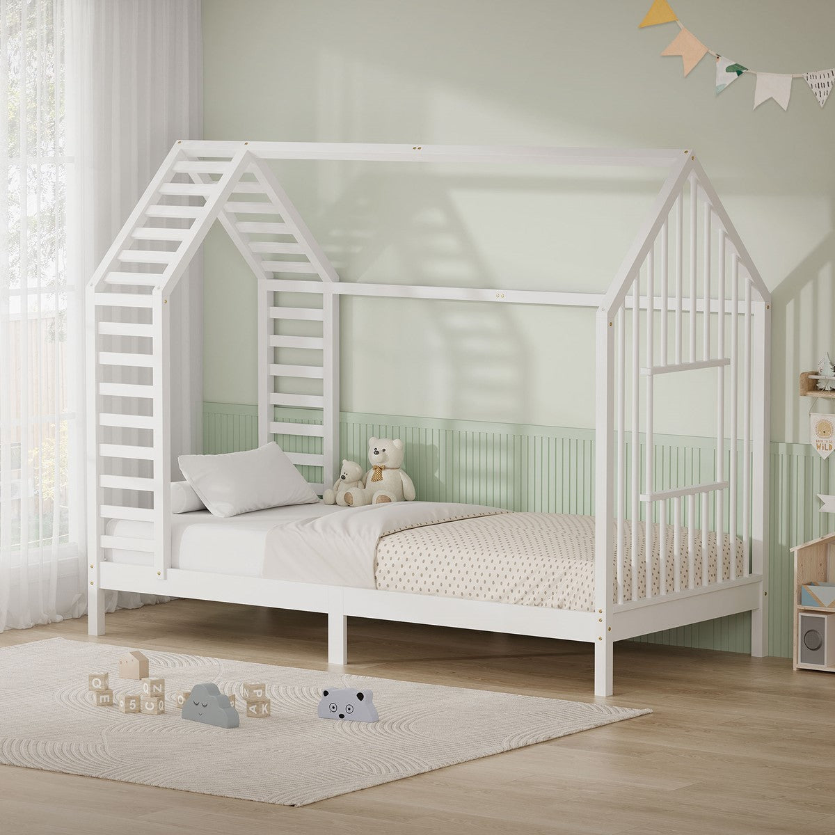 Weißes Kinderbett in Hausform mit Spielzeug auf dem Boden.