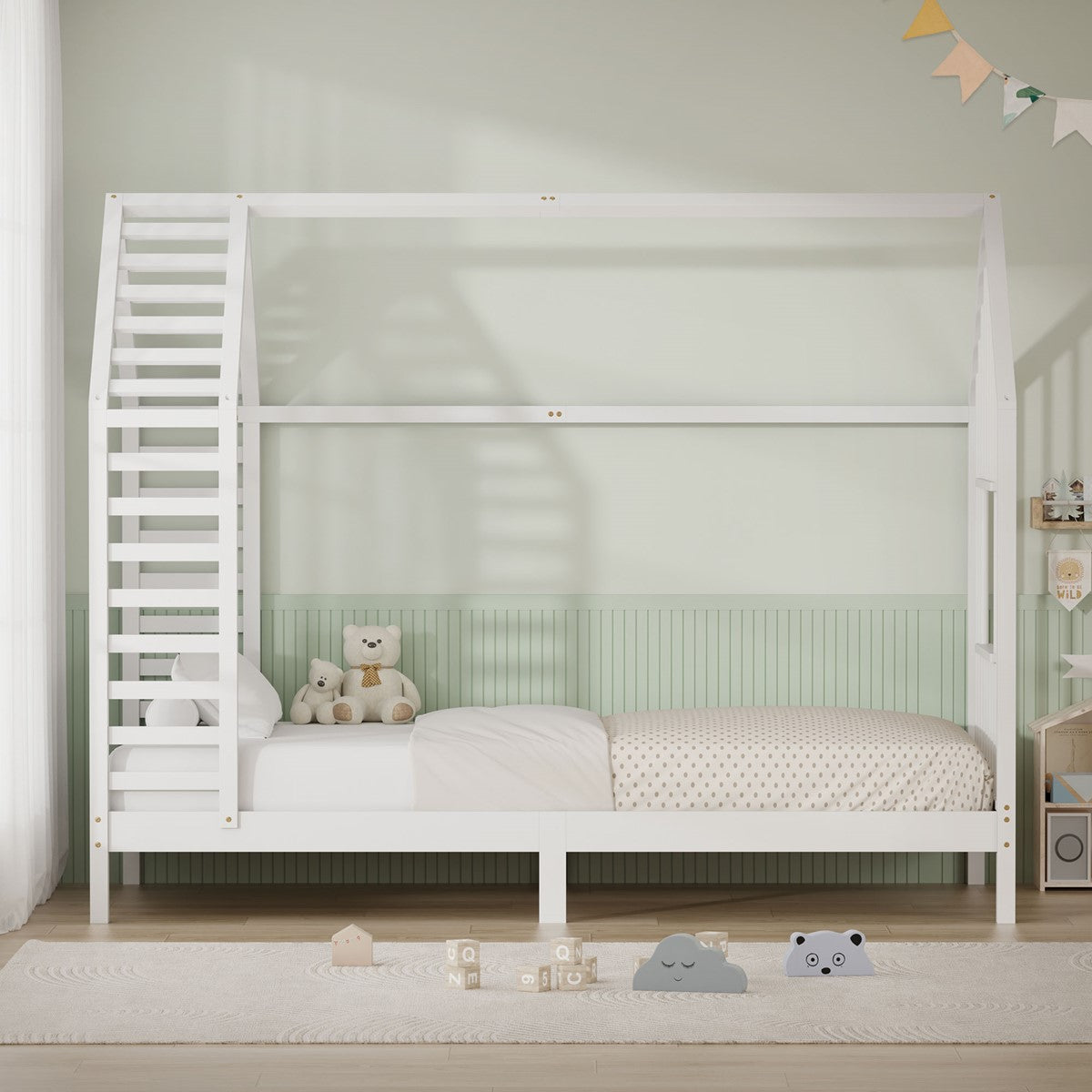Ein weißes Kinderbett mit einer Leiter und Spielzeug im Raum.