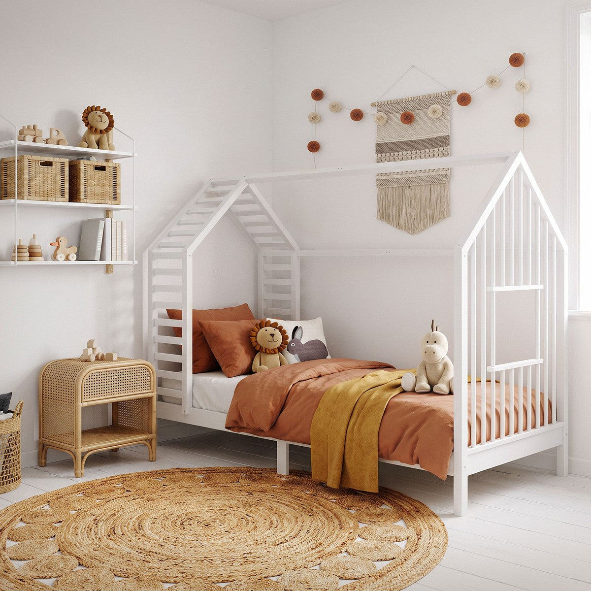 Ein Kinderzimmer mit einem Bett in Hausform, Teppich und Wanddekoration.