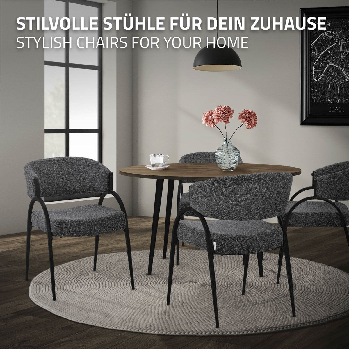Drei graue Polsterstühle mit schwarzen Metallgestellen stehen an einem runden Esstisch in einem Wohnraum.
