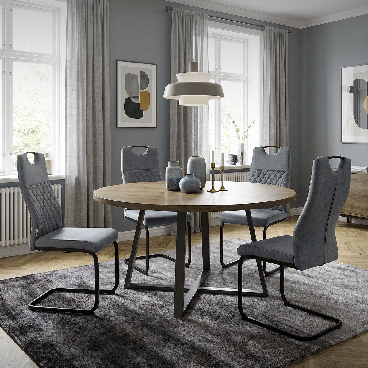Graue gepolsterte Freischwinger um einen runden Holztisch in einem hellen Esszimmer.