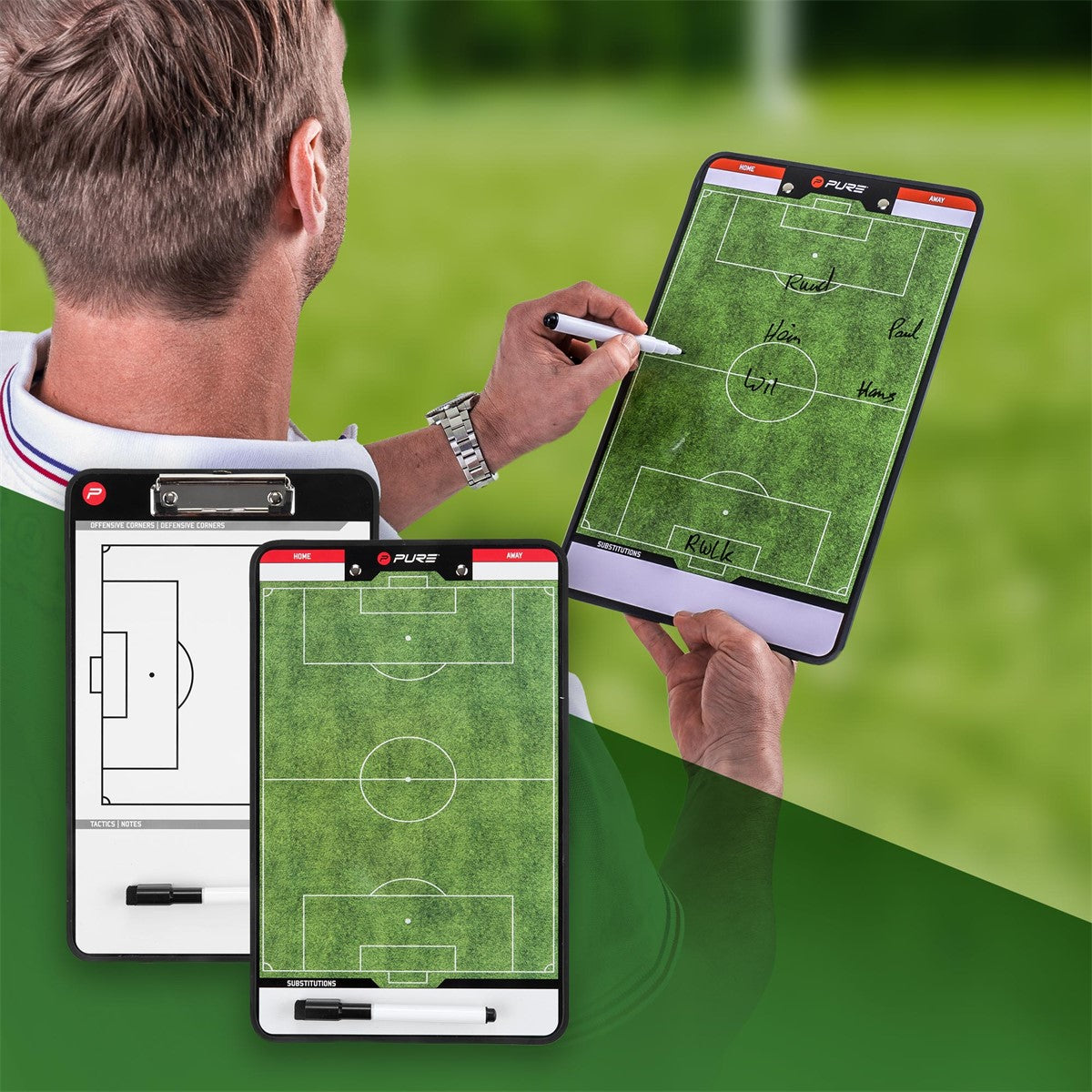 Entrenador con pizarra táctica en un campo de fútbol, notas sobre el terreno de juego.