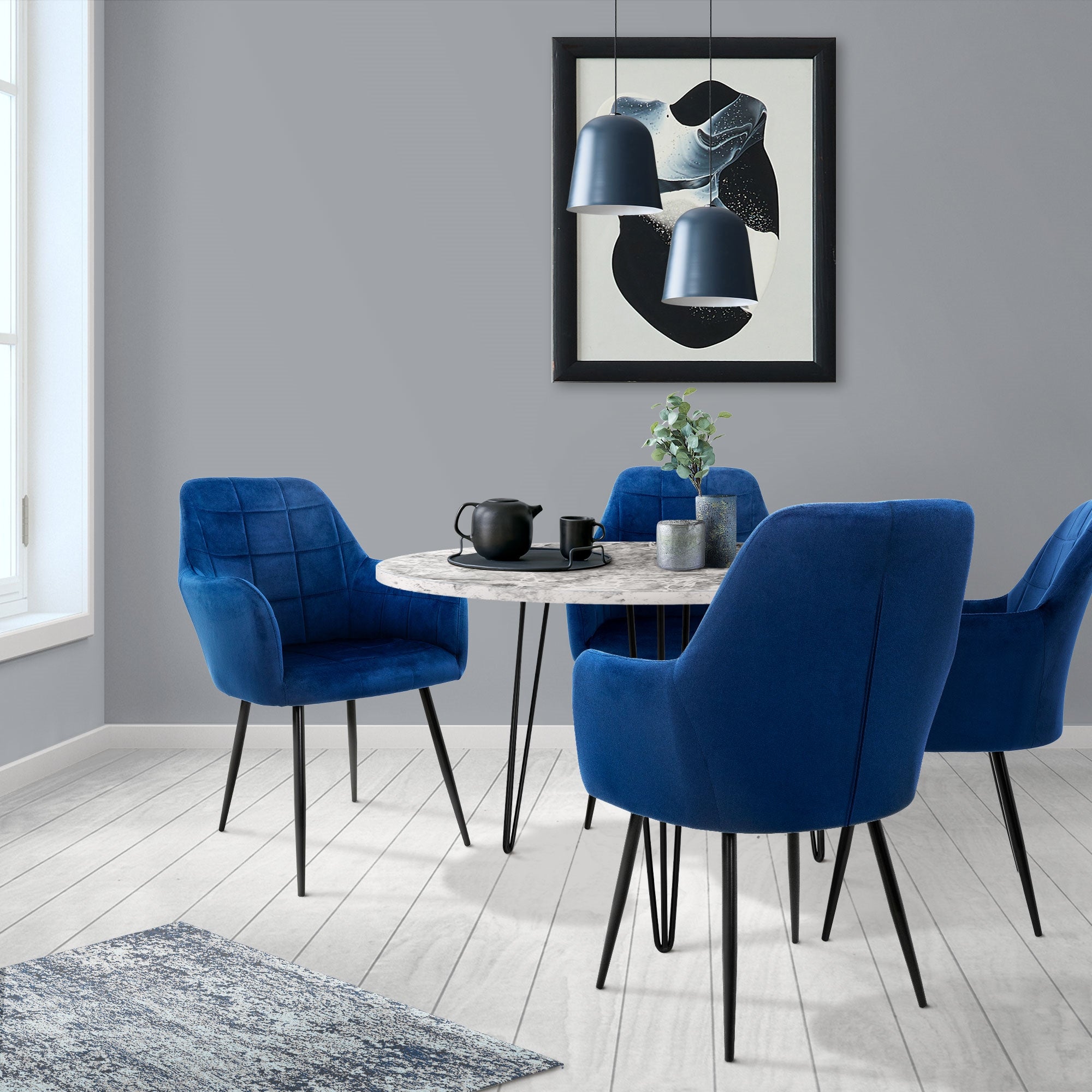 Essbereich mit runden Tisch und vier blauen Stühlen.