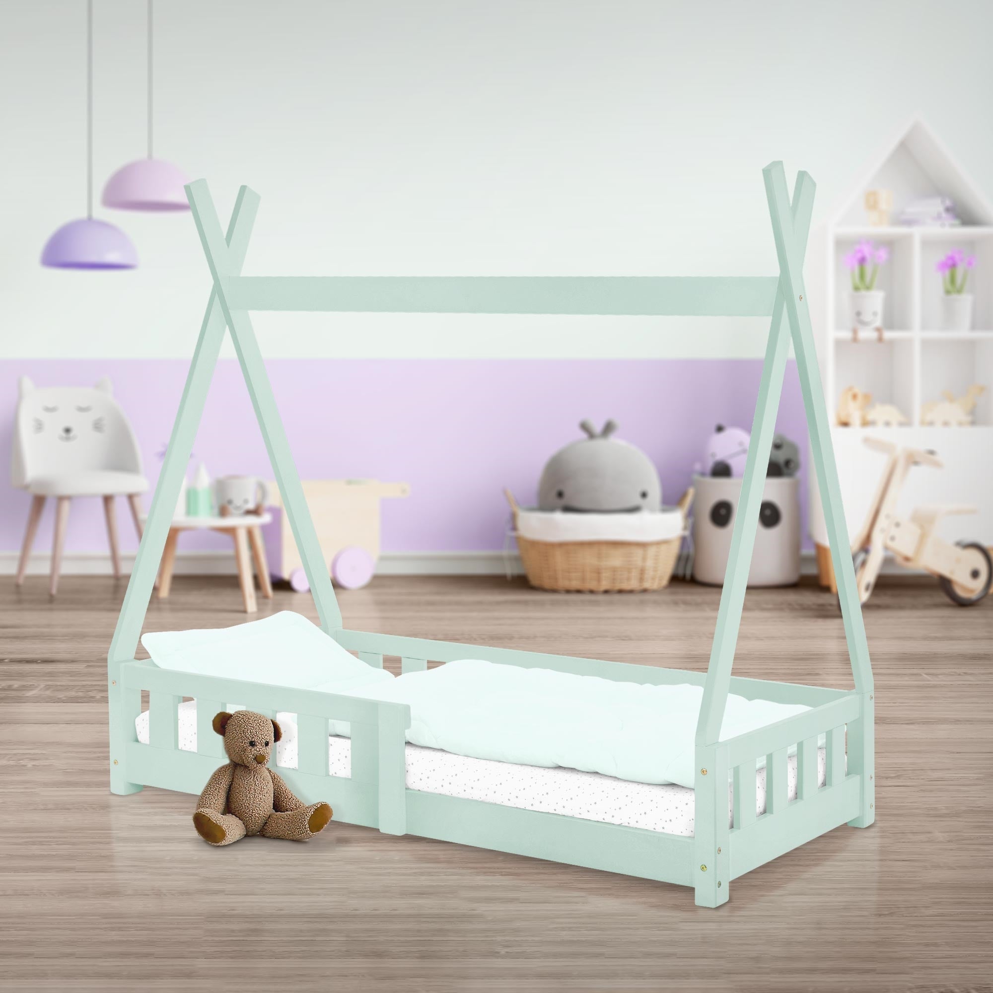 Ein Kinderbett im Zeltstil mit einem Teddy und Kissen.