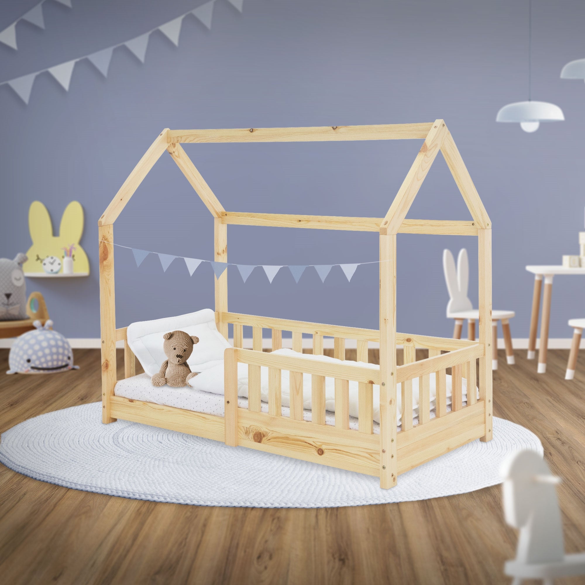 Lit en bois pour enfants en forme de maison avec un ours en peluche et un coussin sur un matelas.
