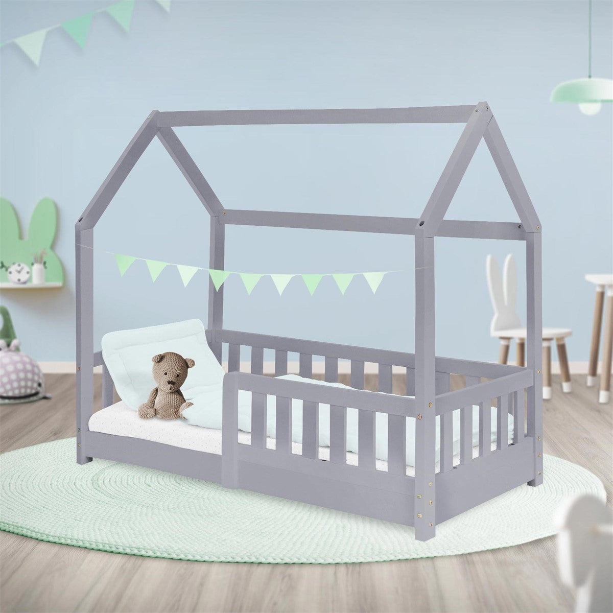 Een kinderbed in een kamer met decoratie en een kussen.