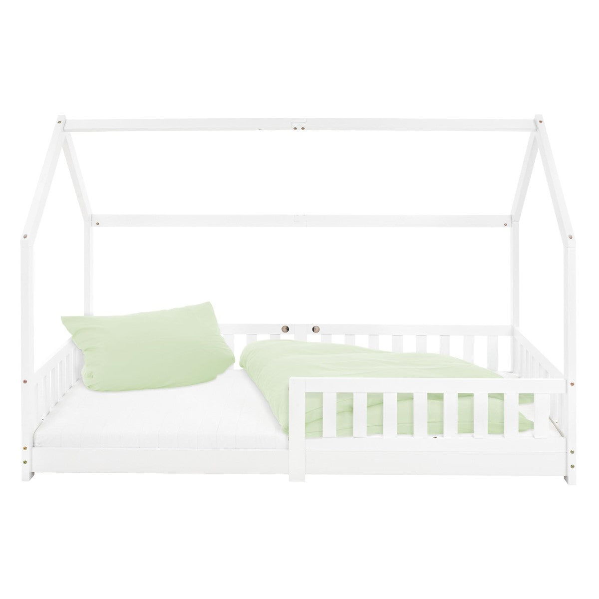 Ein weißes Bett mit grünem Kissen und Decke, in einem hellen Raum.