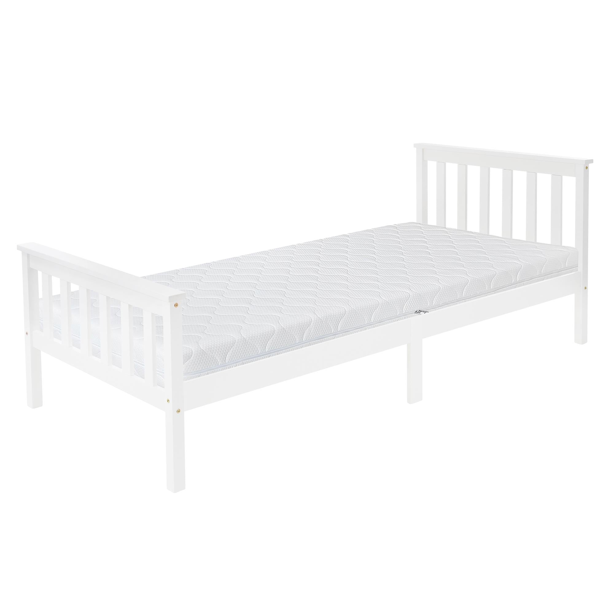 Weißes Bett mit Matratze und Kissen in einem hellen Raum.