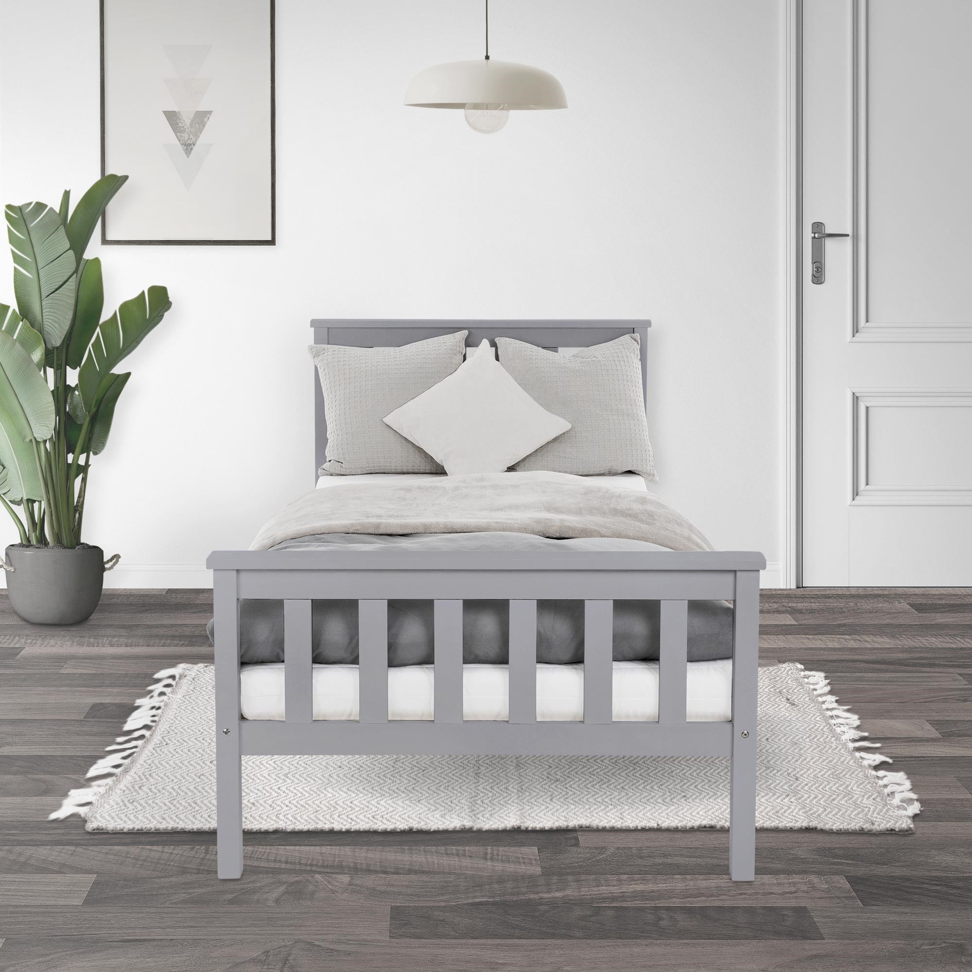 Graues Bett im modernen Raum, mit Kissen und Teppich.