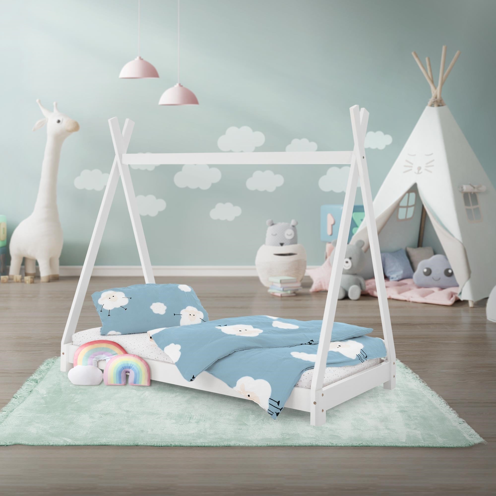 Ein Kinderbett mit einem Zelt-Design, umgeben von Spielzeug und einer bunten Decke.