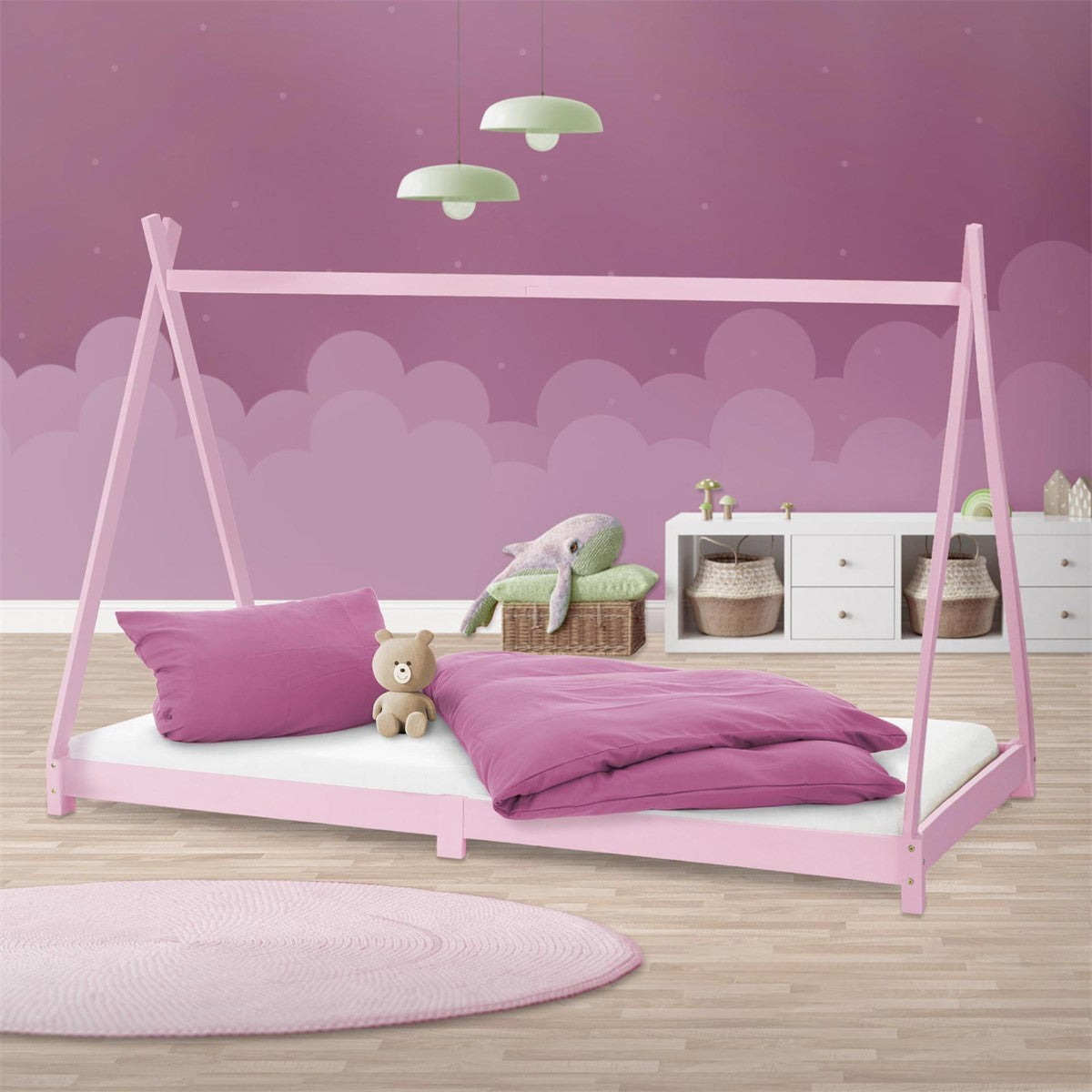A pink children's bed with a pillow and a stuffed animal.