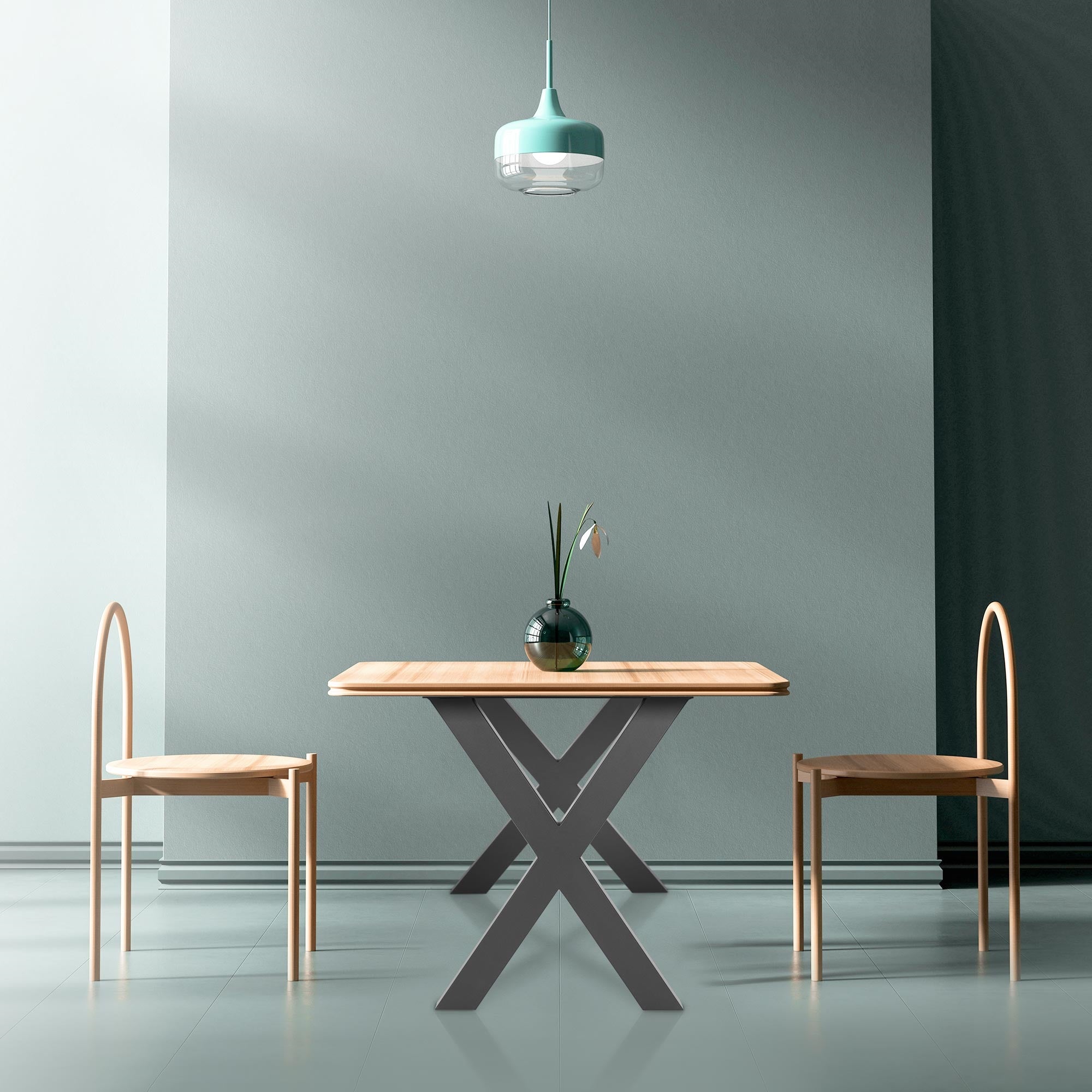 Ein Tisch mit zwei Stühlen in einem Raum mit grauen Wänden und einer Lampe.