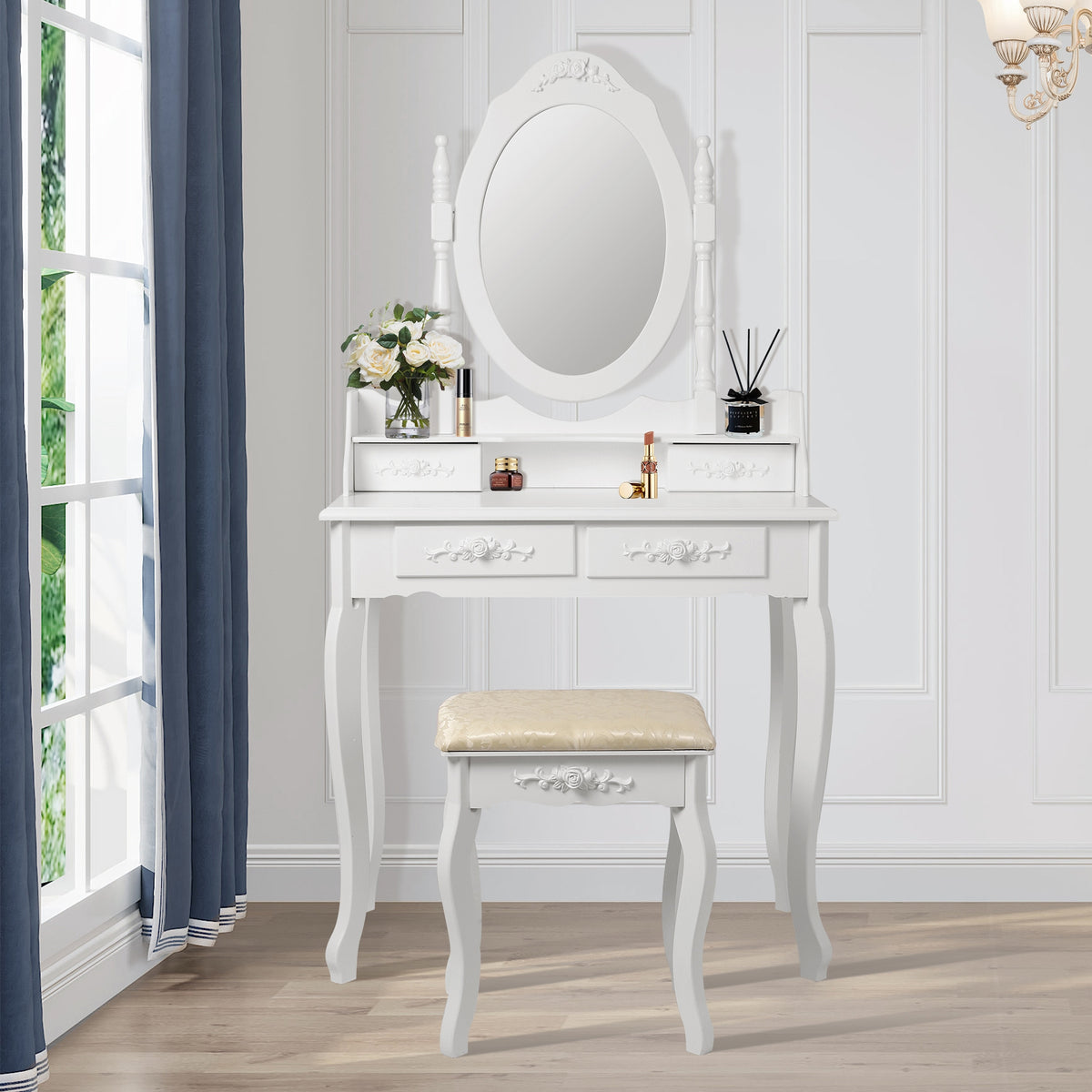 A white dressing table with mirror and flowers in a bright room.