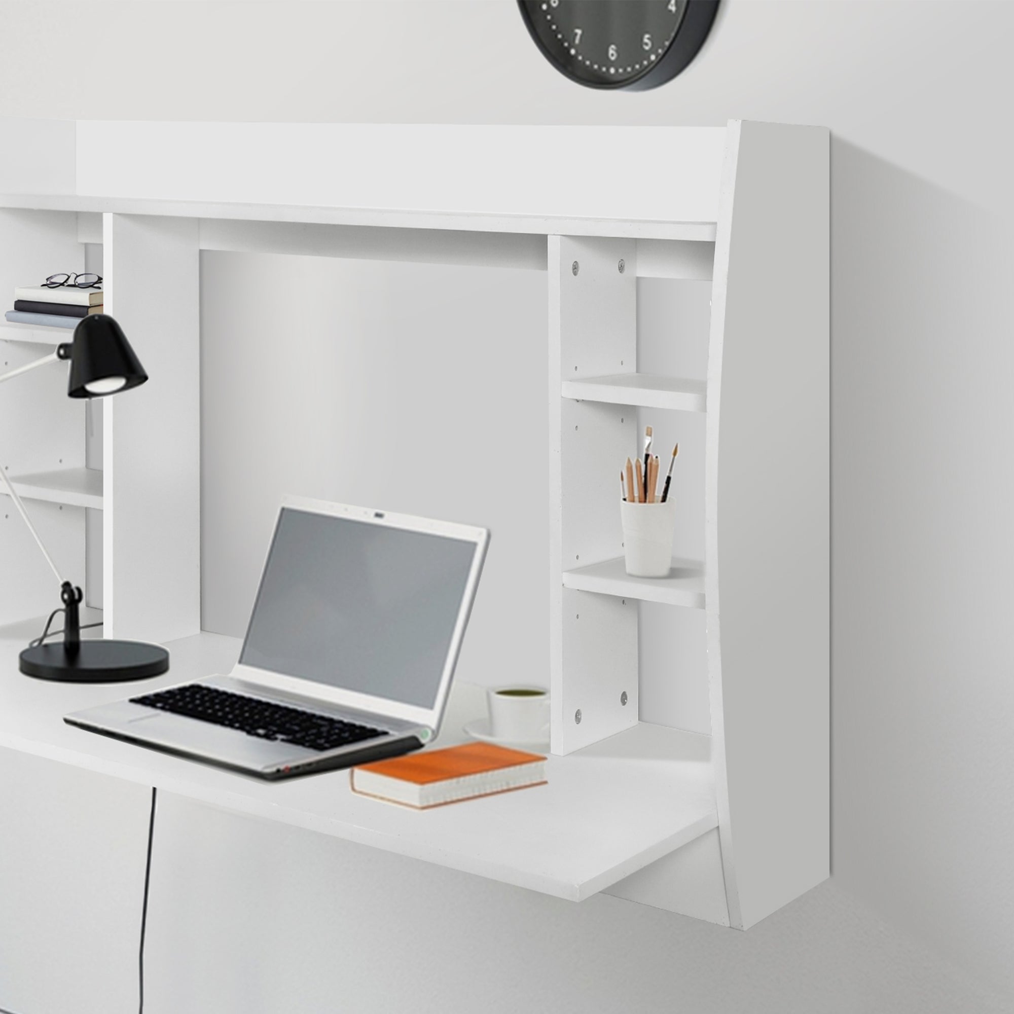 White desk with a laptop, lamp, and shelves.
