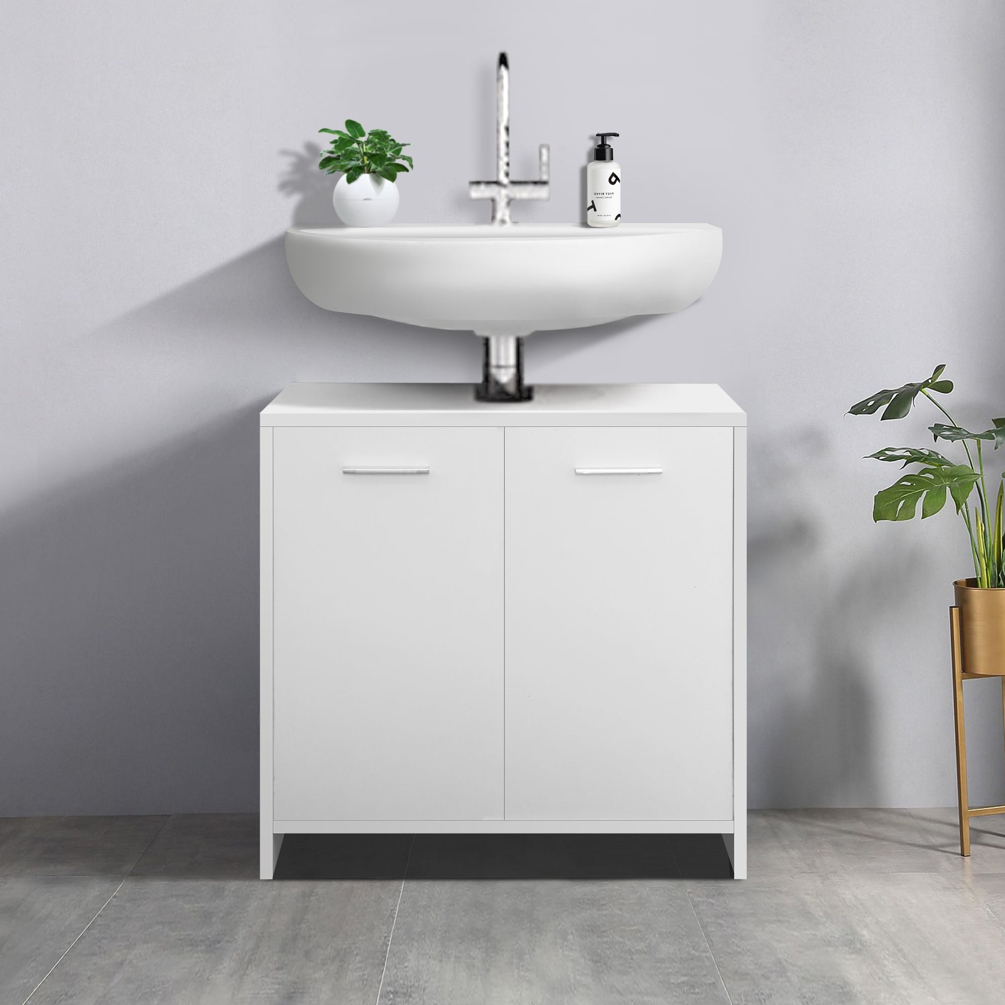 Mobile sottolavabo bianco con lavabo e una pianta accanto.