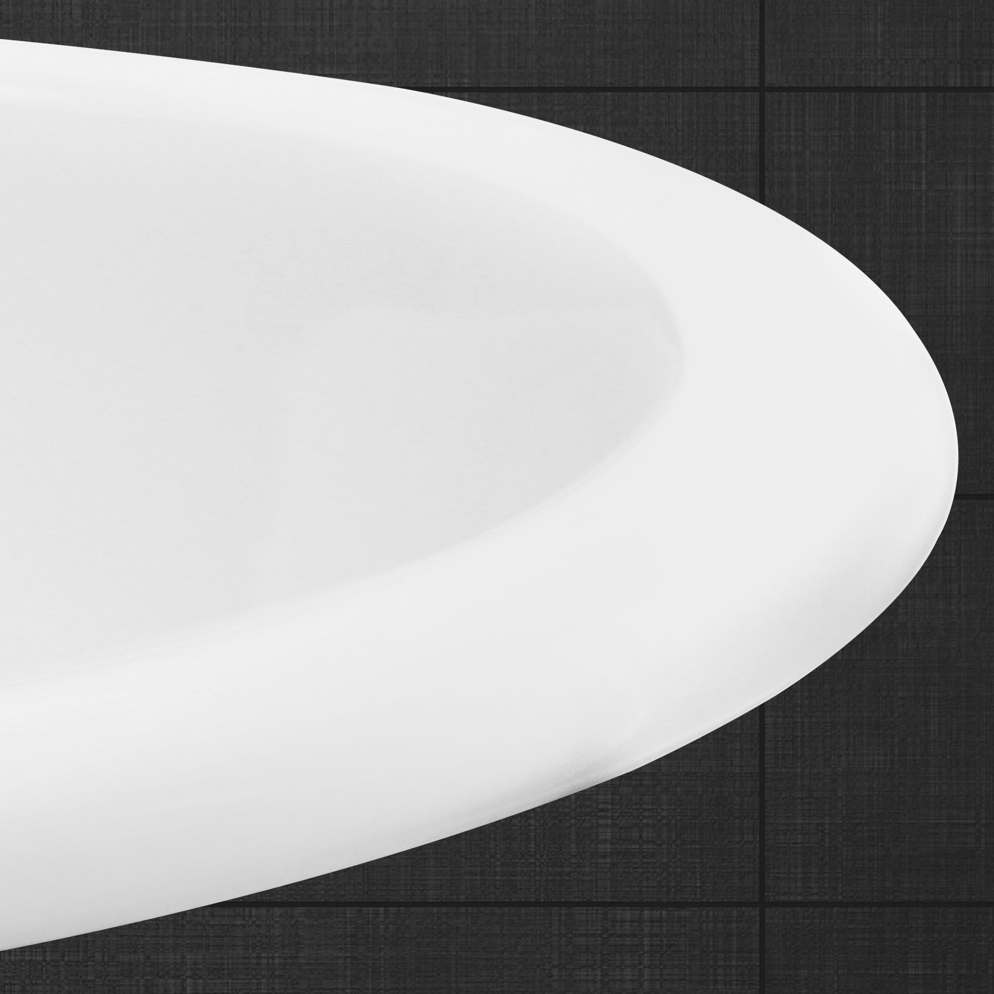 Nahaufnahme der Kante einer weißen Badewanne auf dunklem Fliesenboden.