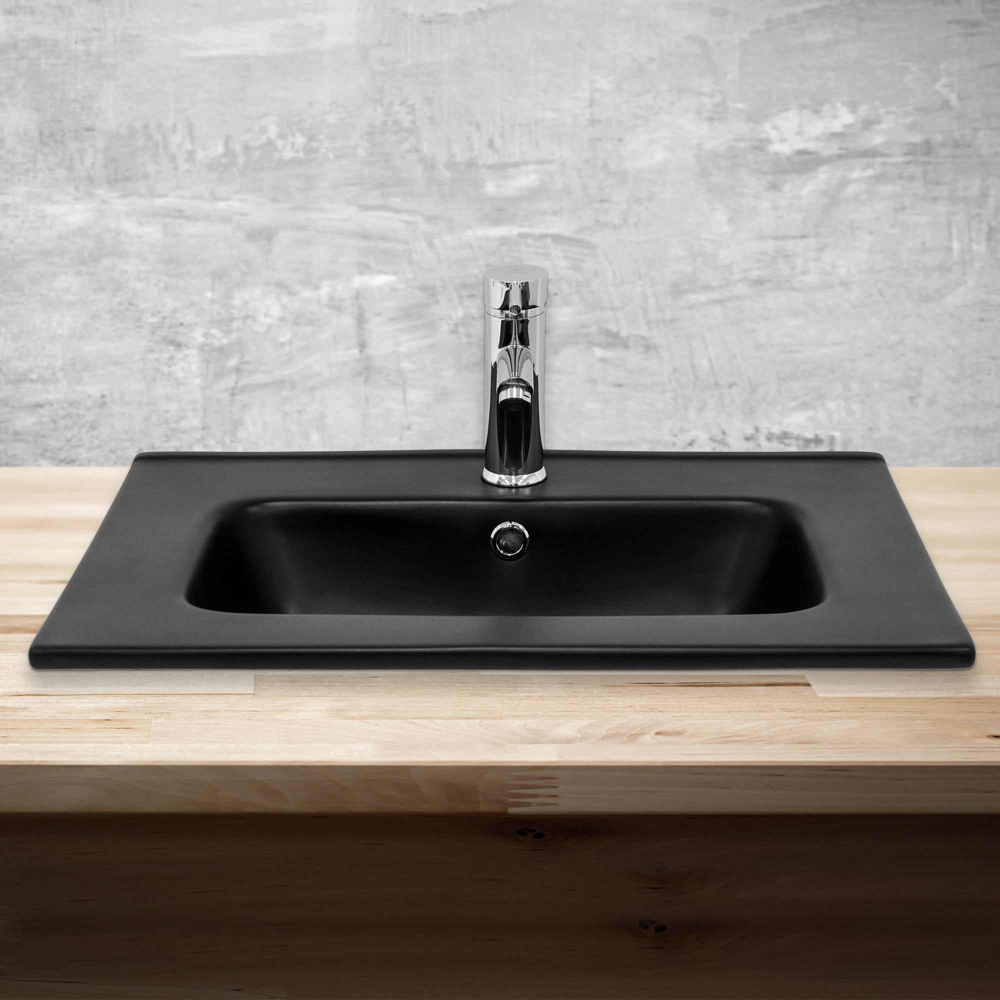 Schwarzes Waschbecken mit Wasserhahn auf einer Holzoberfläche.