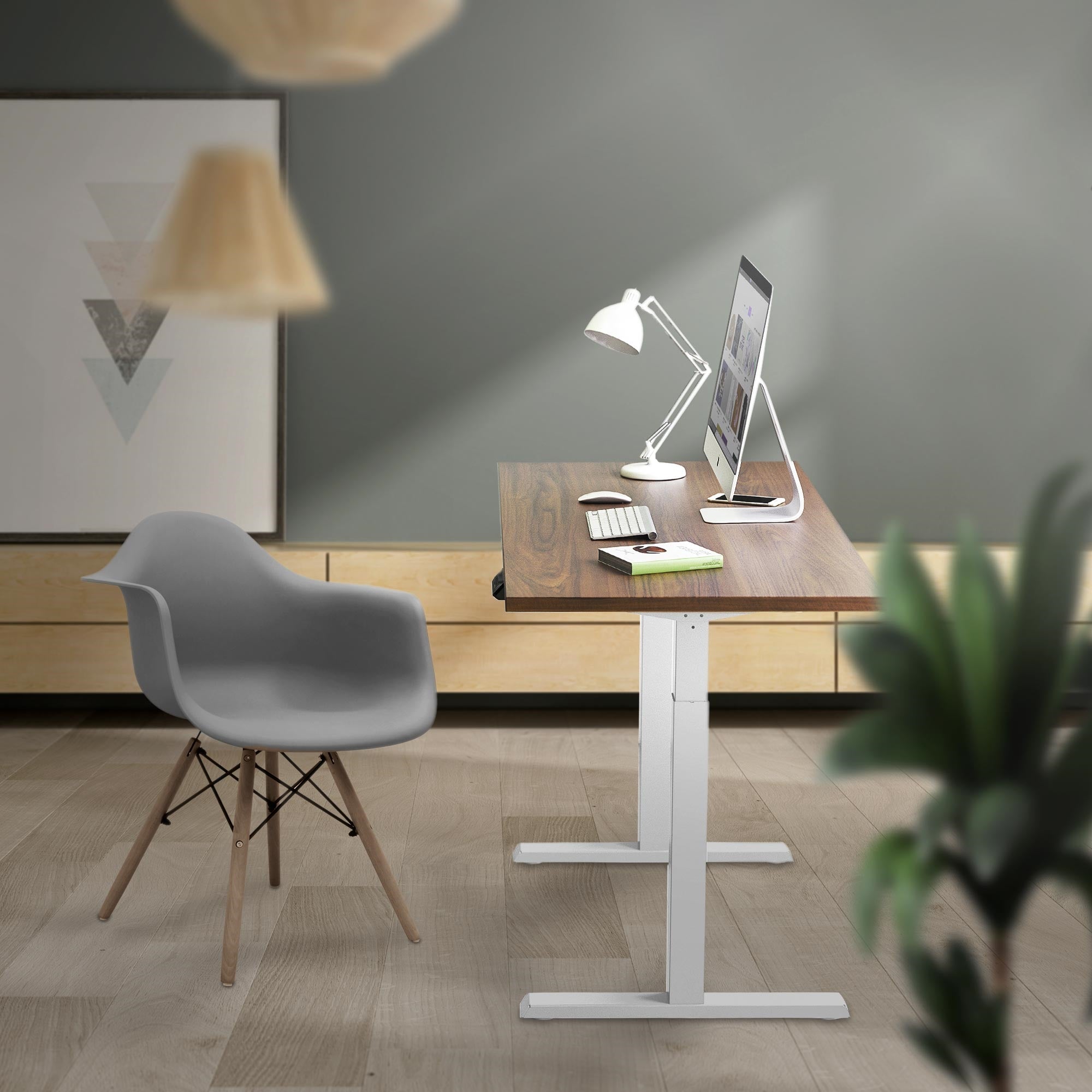 Moderner Arbeitsplatz mit Stehtisch, Computer und Schreibtischlampe.