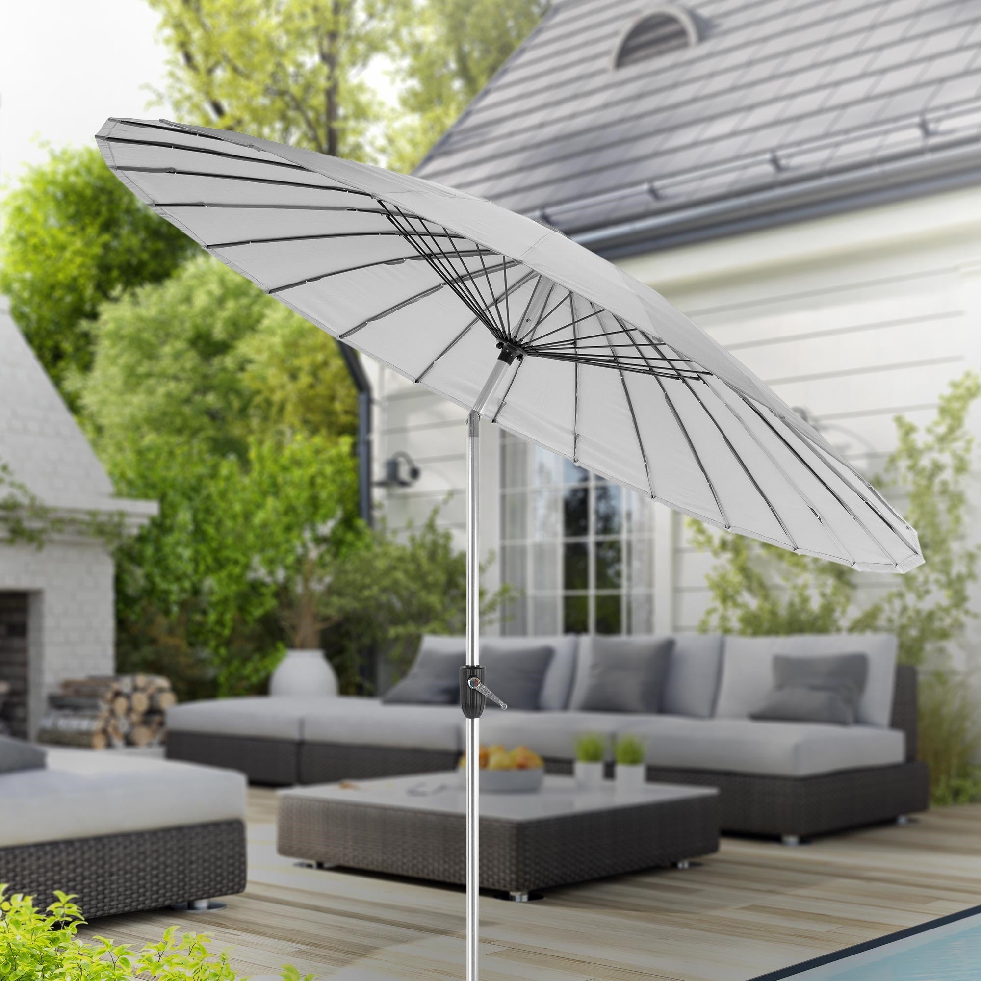 Parasol blanc sur une terrasse avec des meubles en arrière-plan.