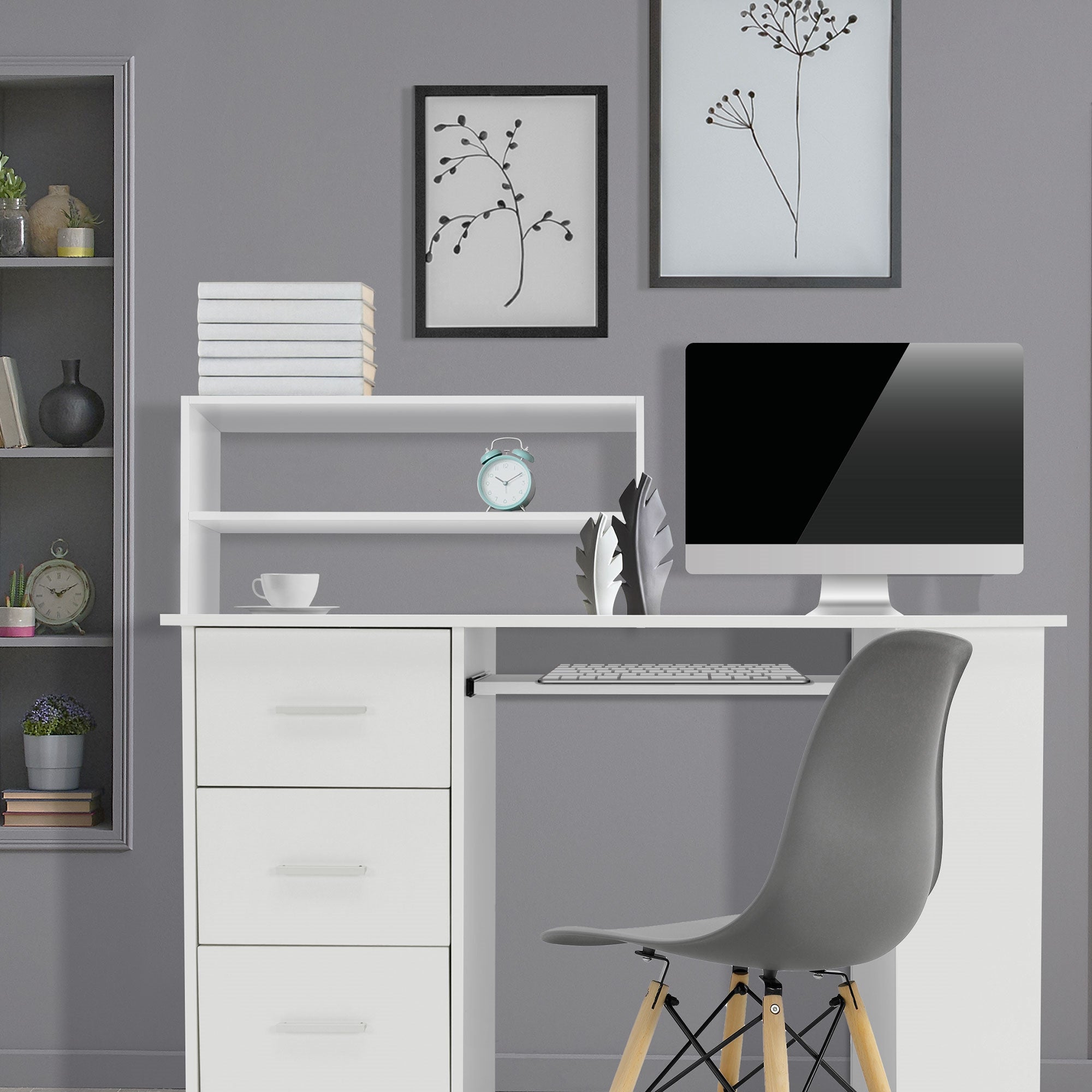 Bureau avec ordinateur, chaise et étagères dans une pièce grise.