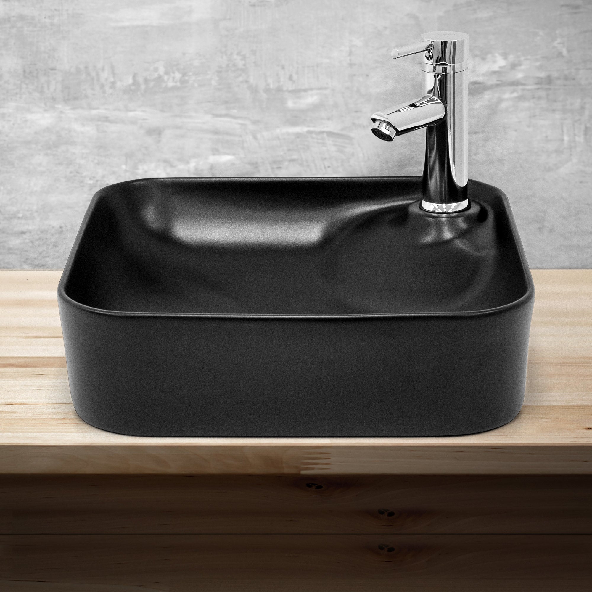 Schwarzes, quadratisches Waschbecken auf einem Holzregal.