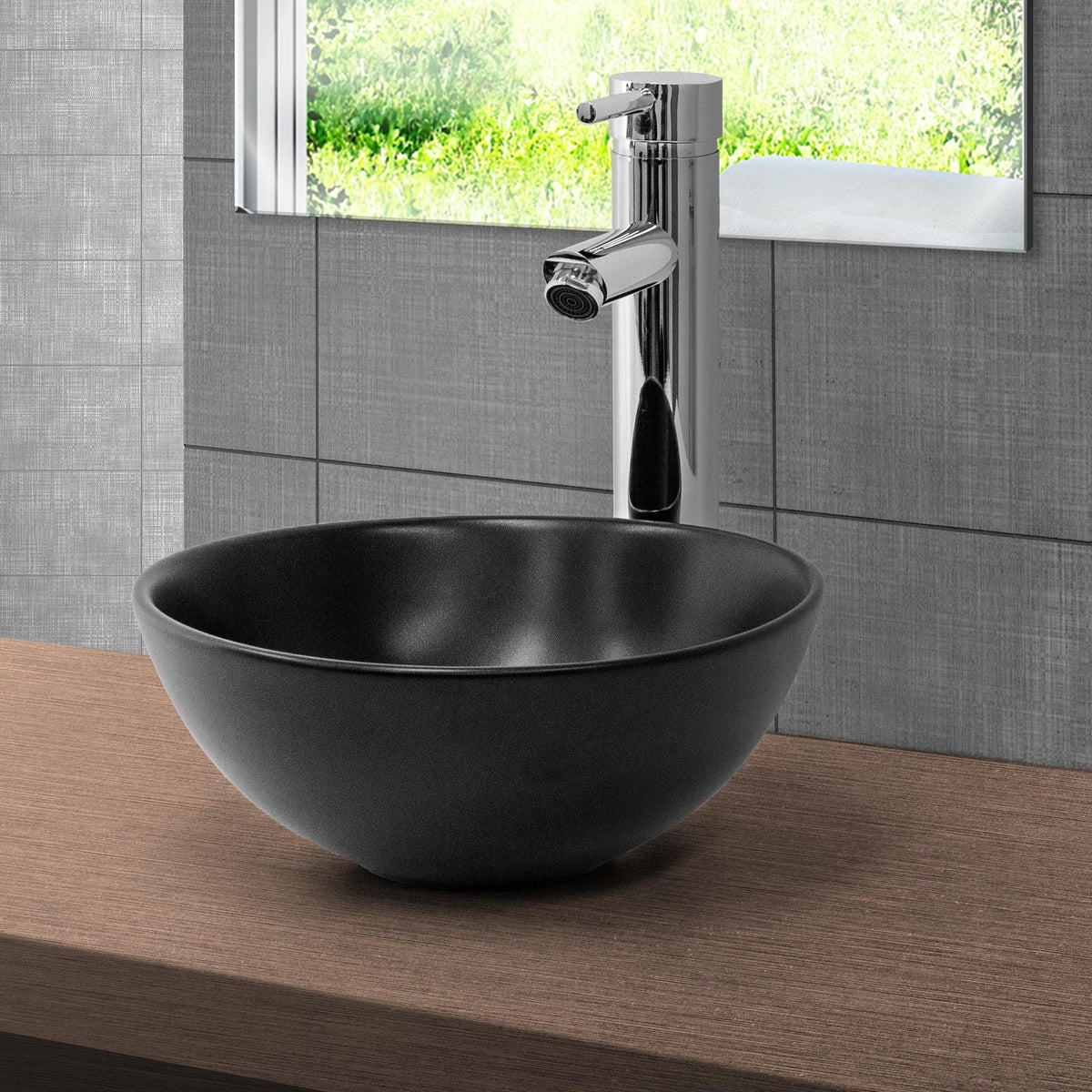 Lavabo rotondo nero su una superficie in legno con rubinetto.
