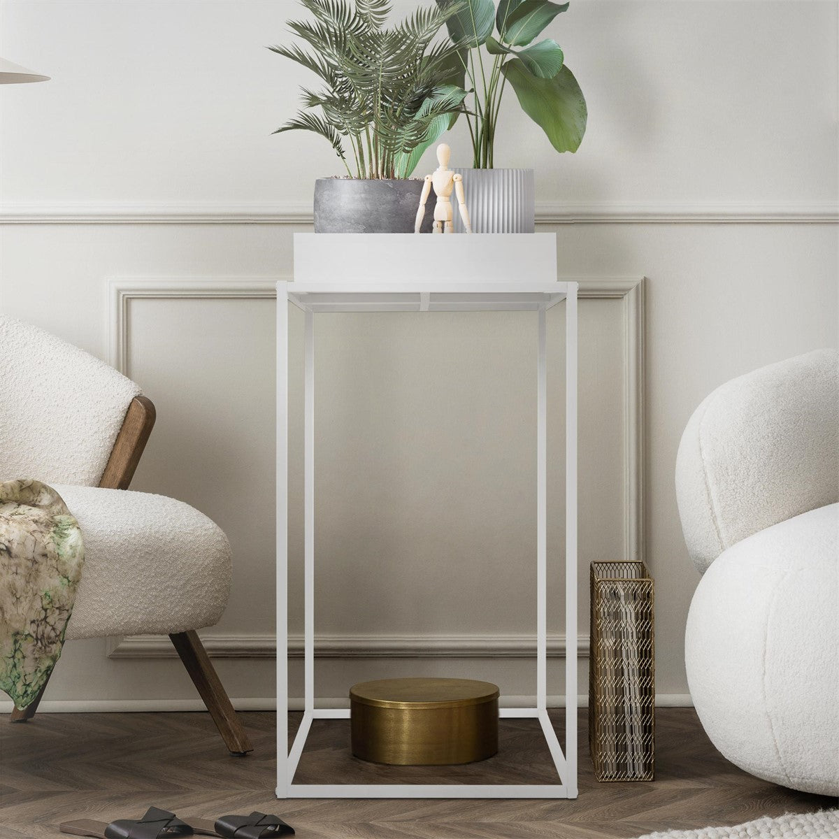 White side table with plants and decorations on the surface.