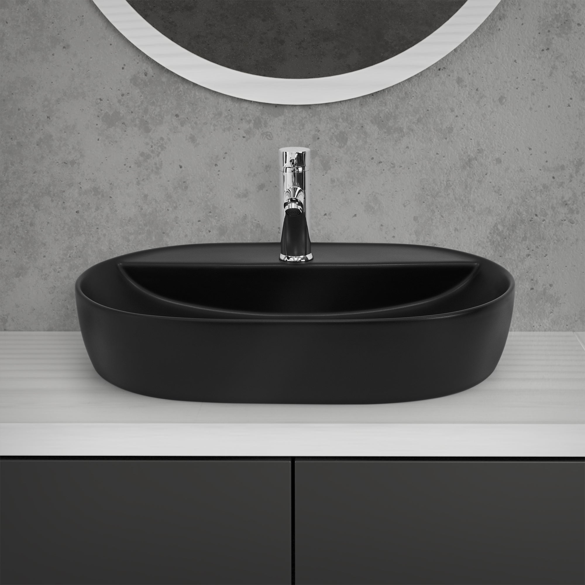 Évier noir ovale sur une table blanche avec un robinet.