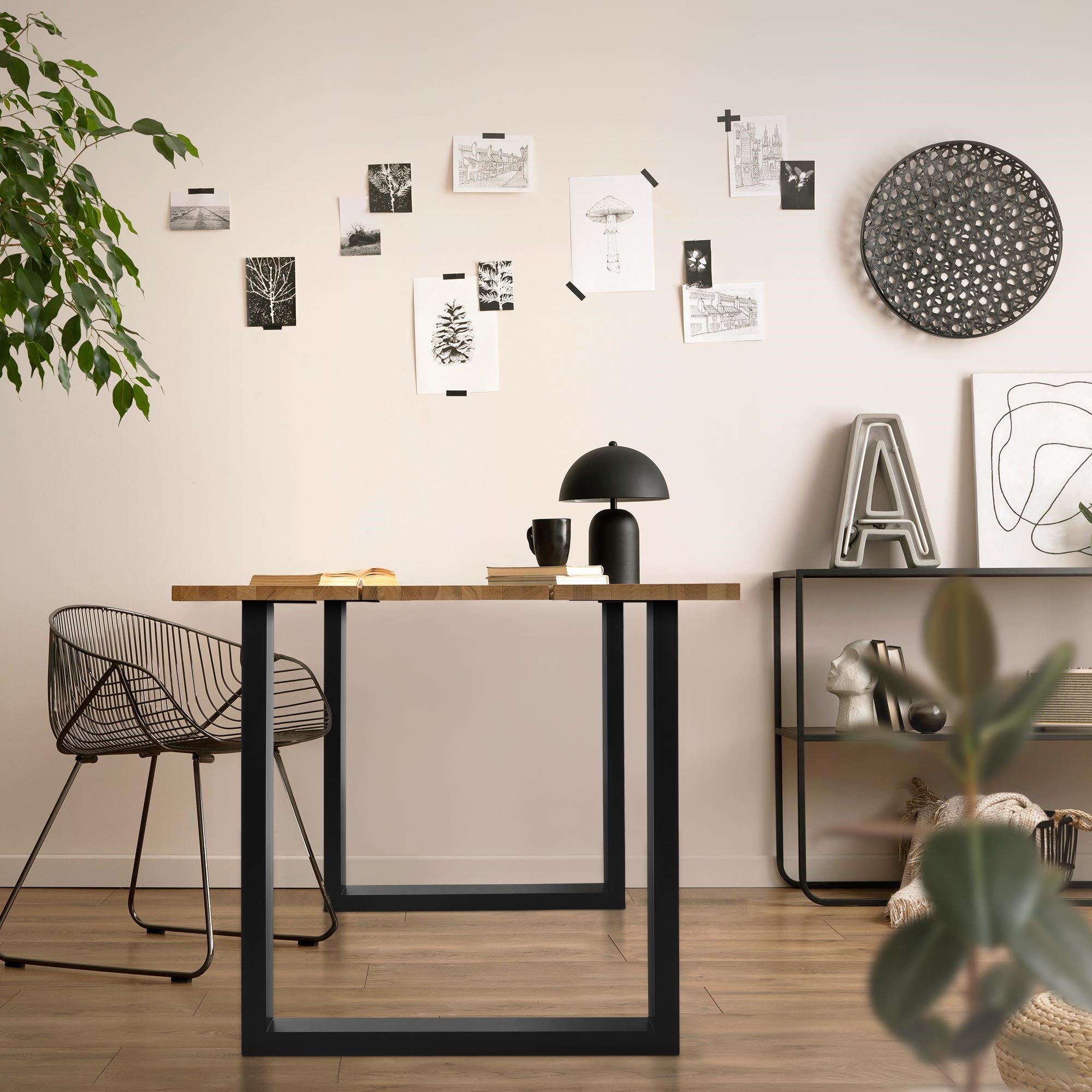 Ein moderner Tisch mit einer Lampe, Stuhl und Bildern an der Wand.