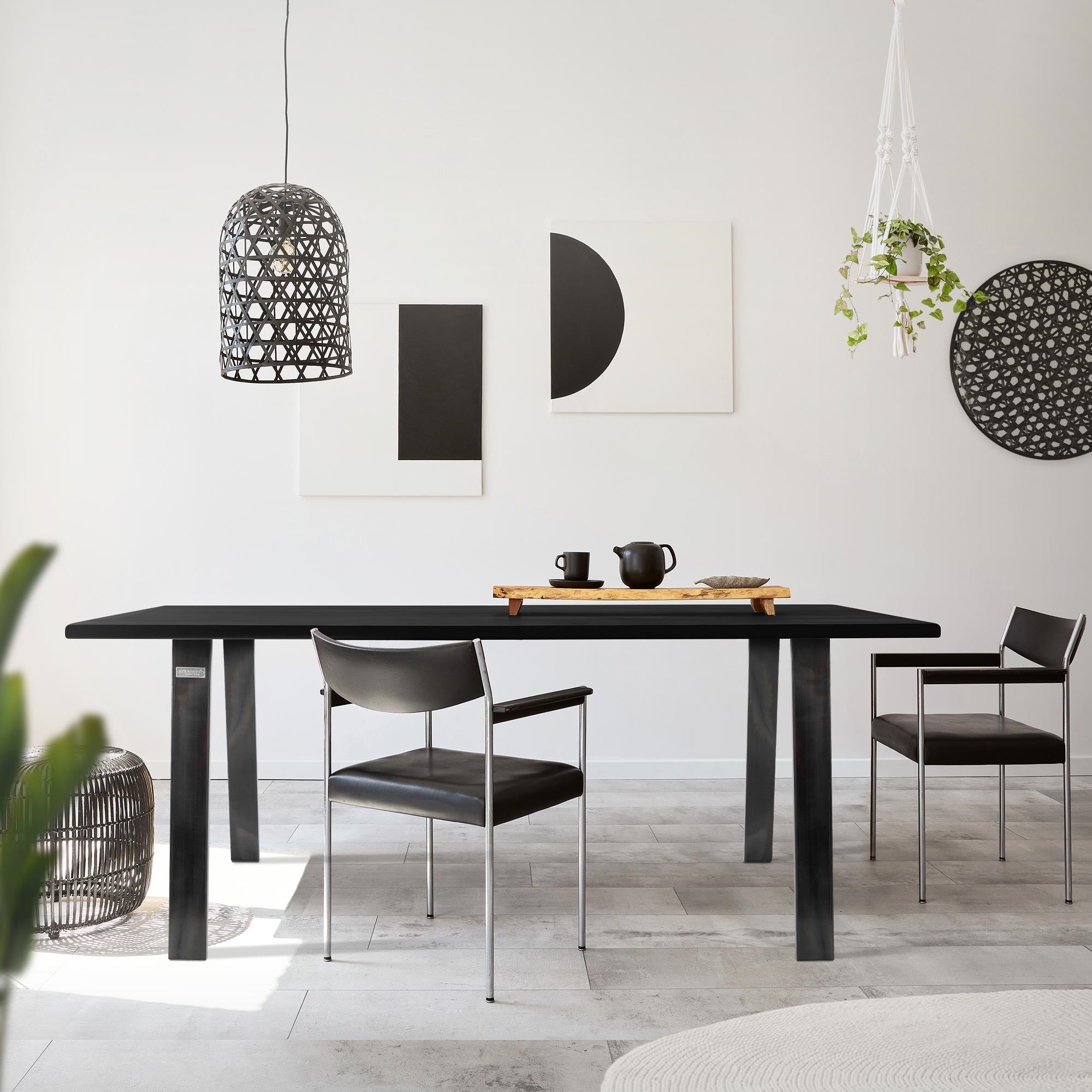 Tafel met zwarte oppervlakte, twee stoelen en decoratieve elementen in de ruimte.