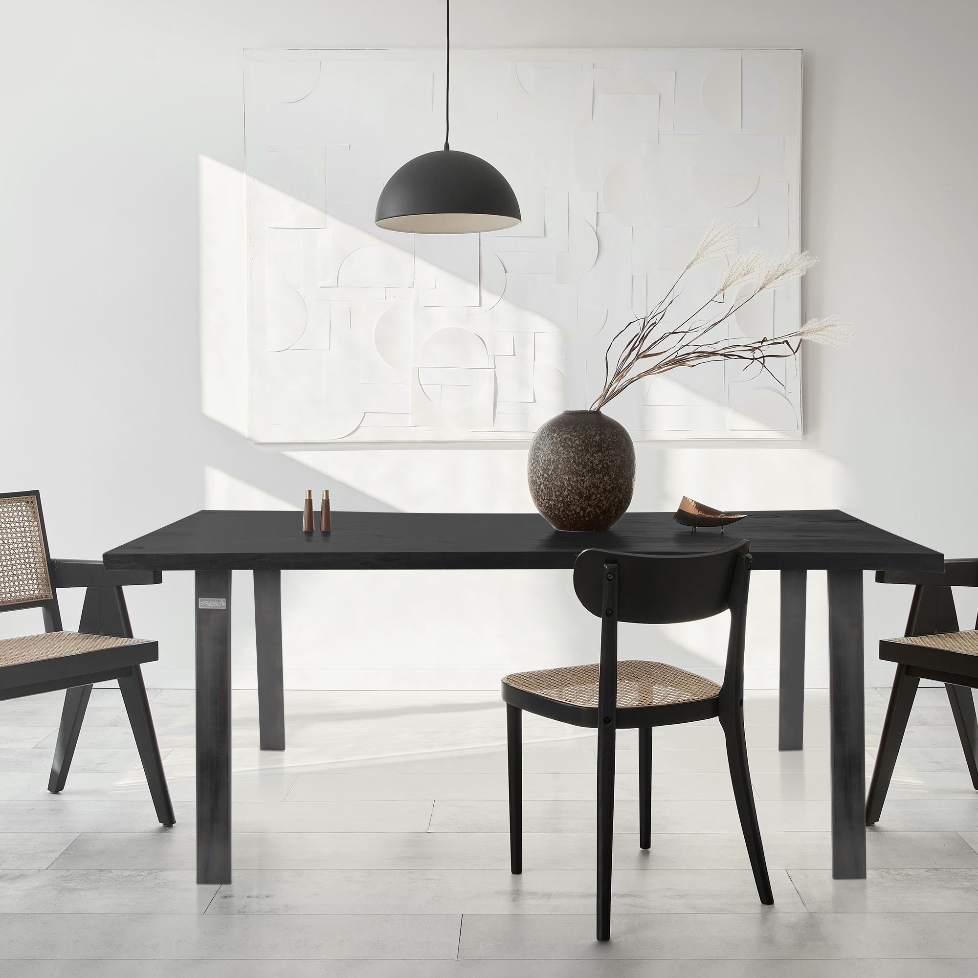 Moderne Essgruppe mit Tisch, Stühlen und Vase, in einem hellen Raum.