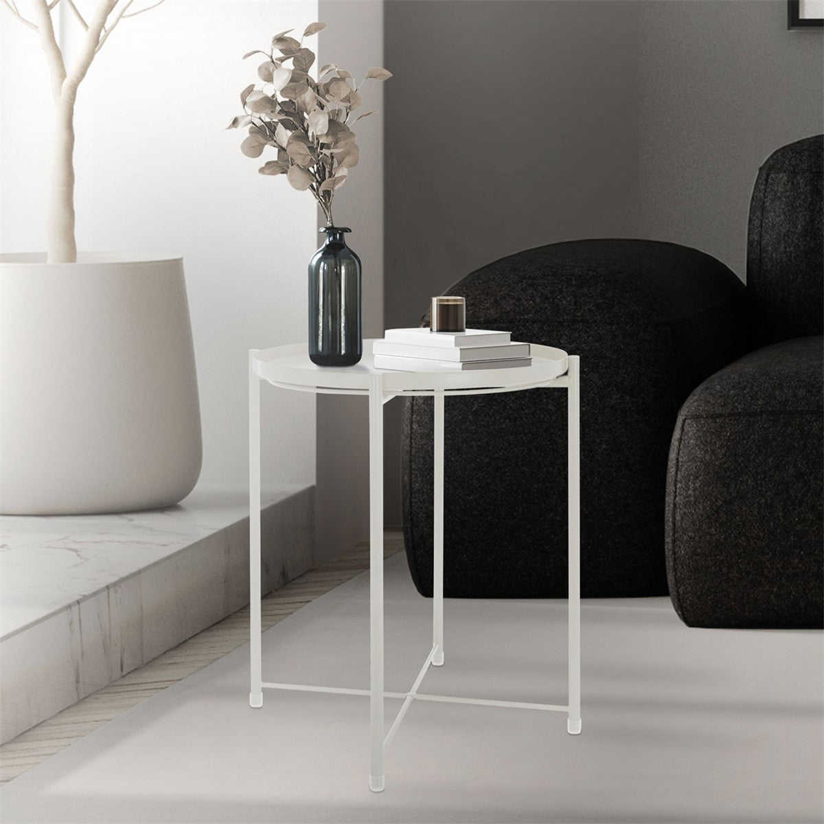 A small table with a vase and a book on a light-colored surface.