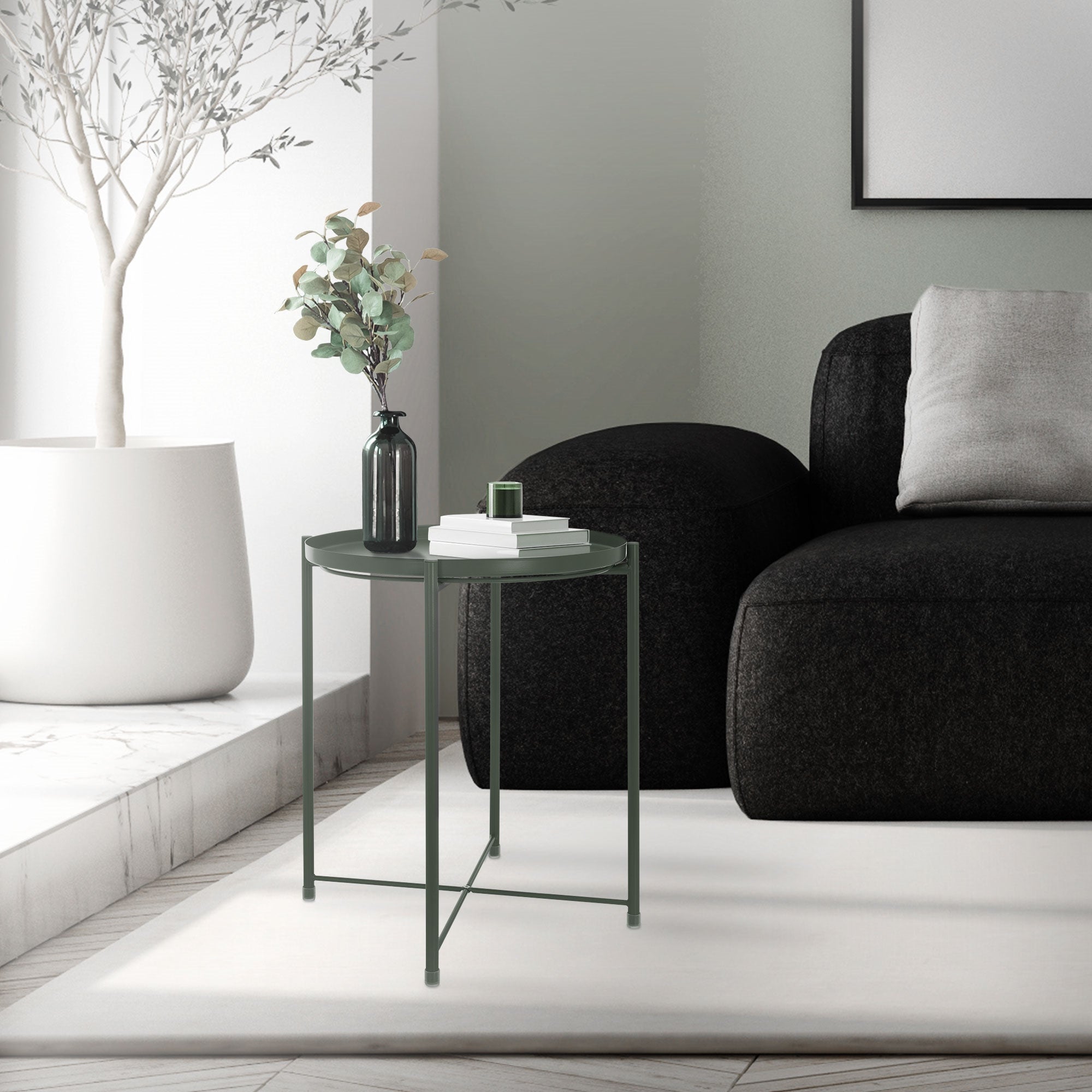 Ein kleiner Tisch neben einem schwarzen Sofa in einem hellen Raum.