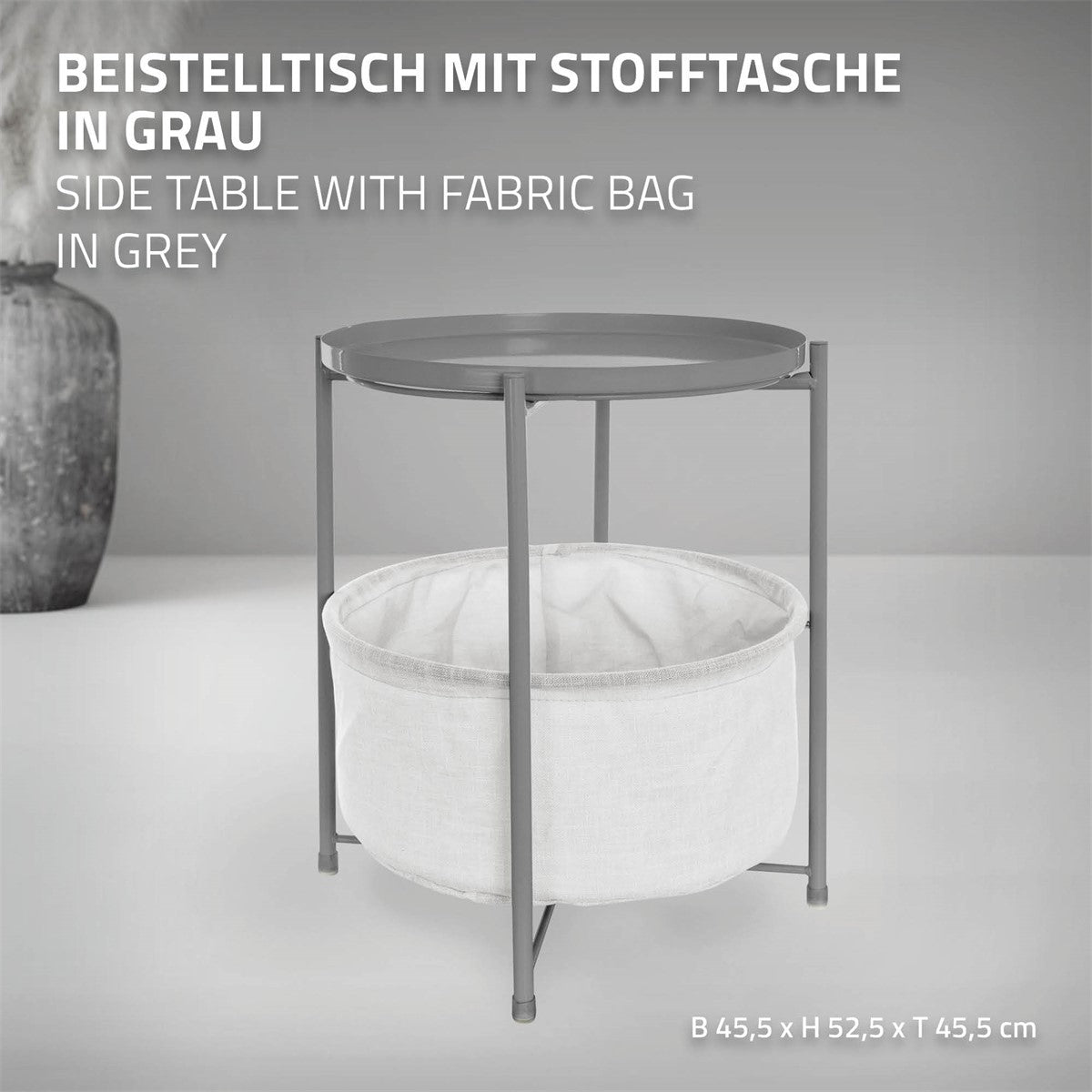 Grauer Beistelltisch mit runder Tischplatte und Stofftasche darunter.